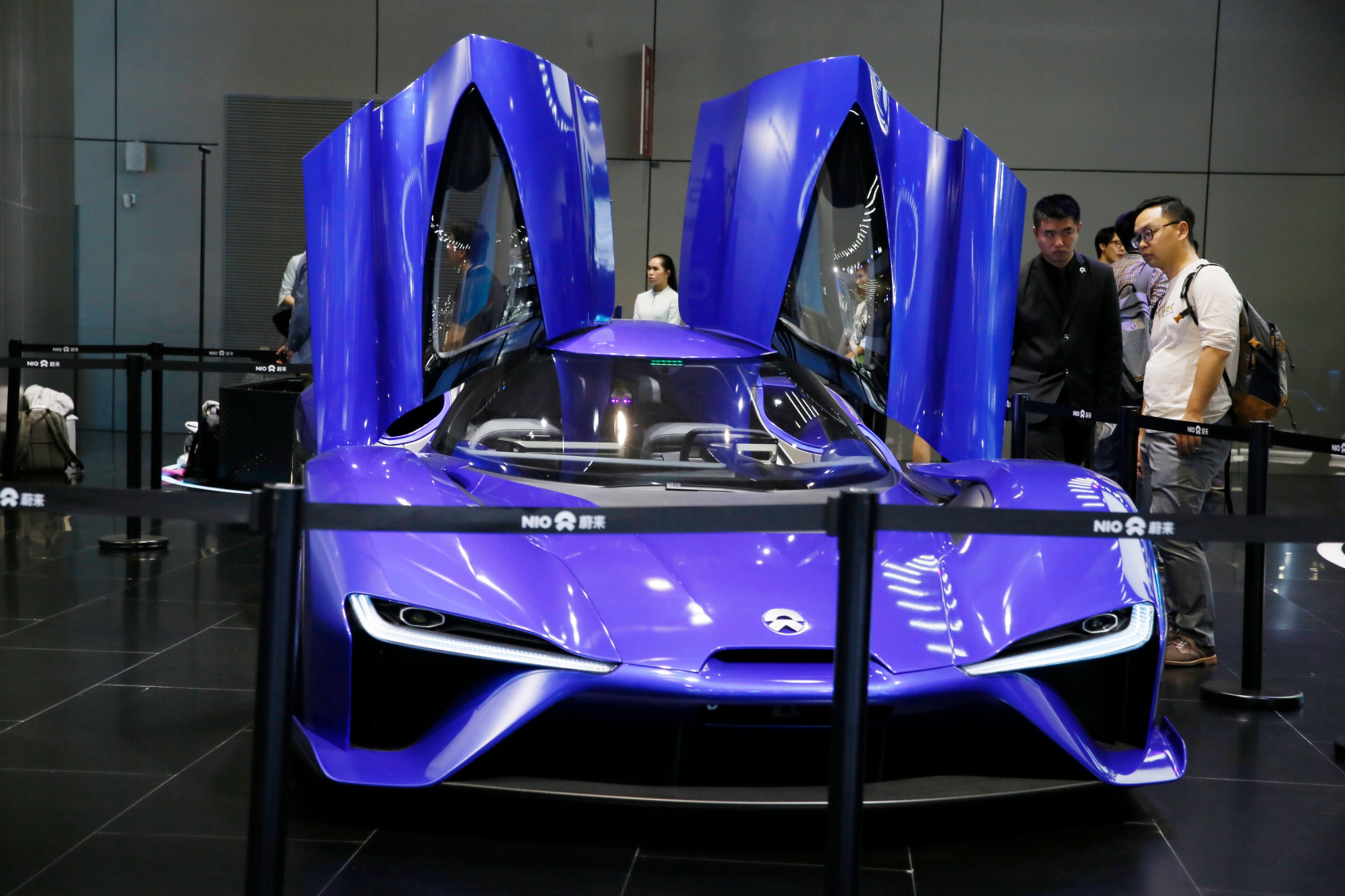 Visitors look at an electric sports car from Chinese startup NIO during the Auto Shanghai 2017 show at the National Exhibition and Convention Center in Shanghai, China, Wednesday, April 19, 2017. Models on display at the Auto Shanghai 2017, the global industry's biggest marketing event of the year, reflect the conflict between Beijing's ambitions to promote environmentally friendly propulsion and Chinese consumers' love of hulking, fuel-hungry SUVs. (AP Photo/Ng Han Guan)