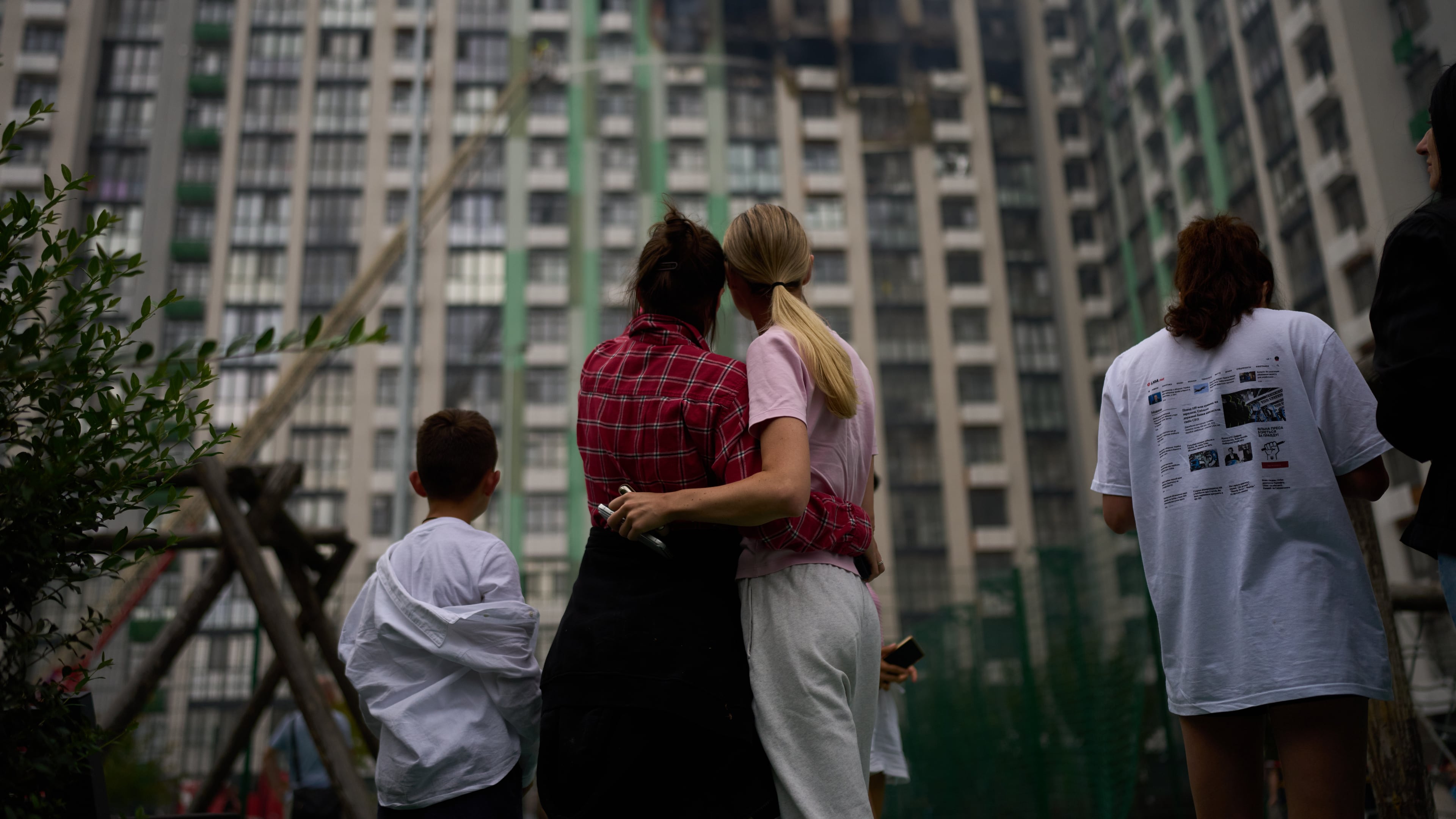 Locals watch as firefighters work after a Russian drone attack struck a residential building in Kyiv, Tuesday, Sept. 1, 2026. (AP Photo/Francisco Seco)