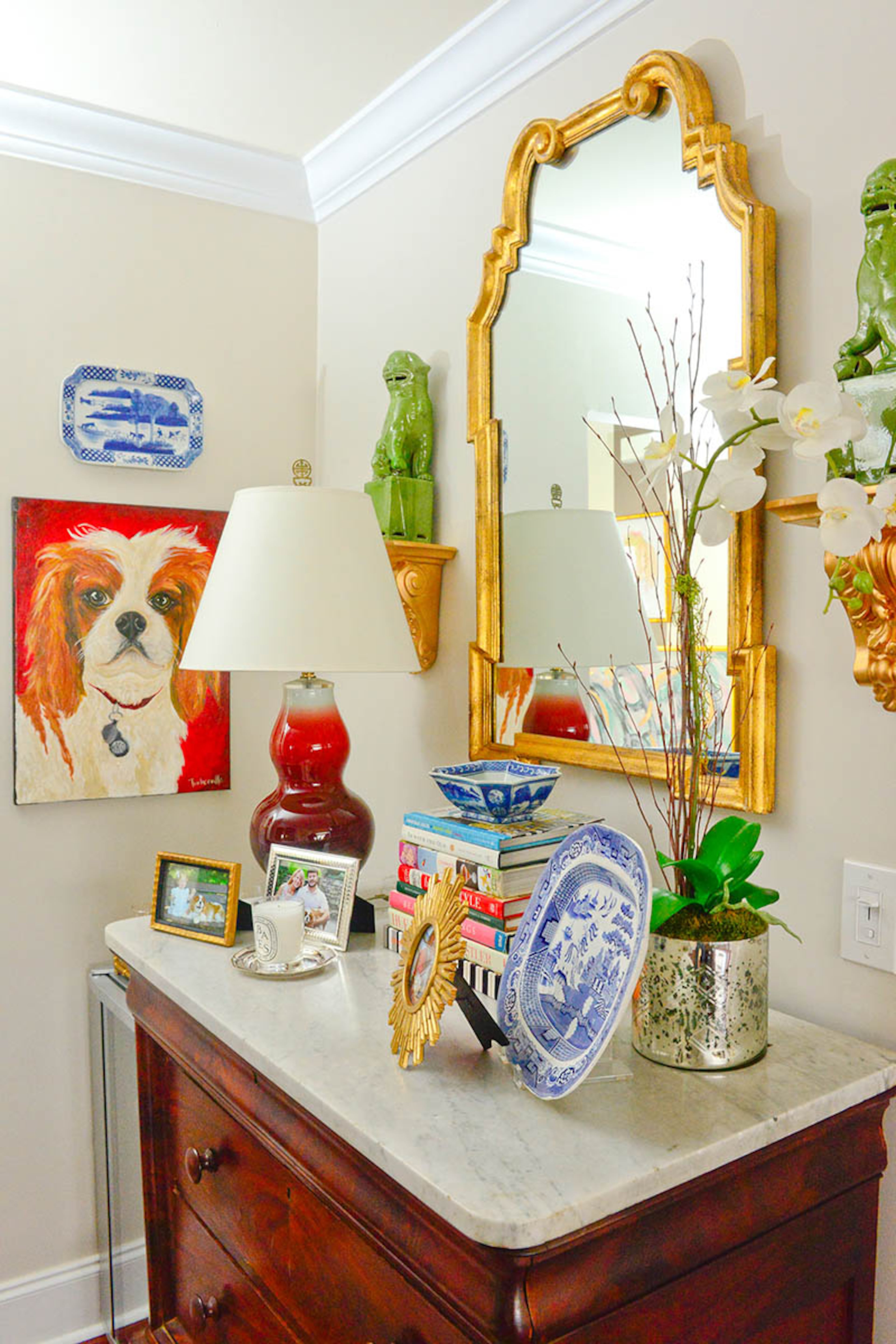 Katie Luepke has several pieces of art by her sister-in-law, Lindsey Turberville Luepke, including a painting of the family dog, Charlie. An antique dresser with marble top that Katie Luepke found at an estate sale acts as a sideboard and display space.