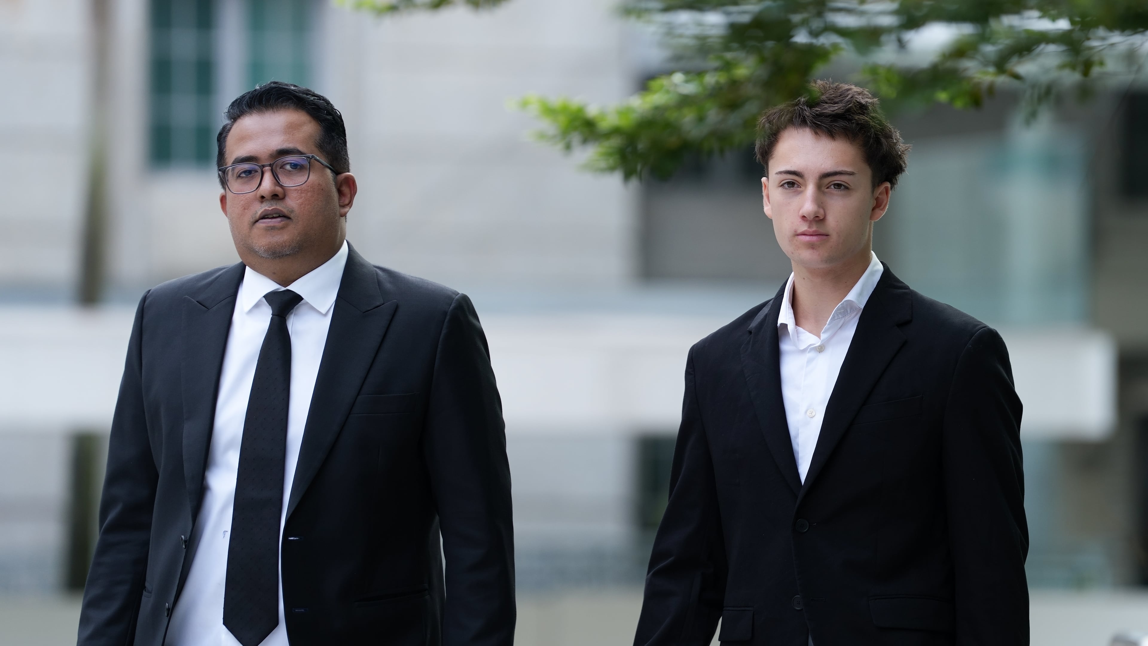 Didier Gaspard Owen Maximilien, right, walks with his lawyers as he arrives at the State Courts building in Singapore, Thursday, Jul. 30, 2026. (AP Photo/David Hu)