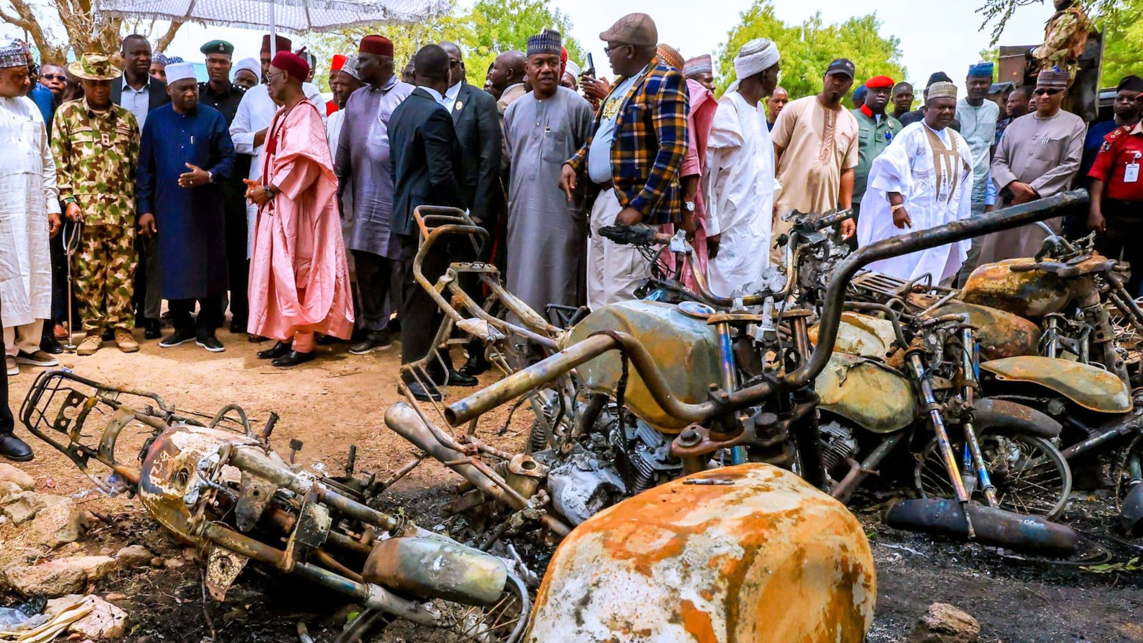In this photo, released by Adamawa State Government House, Adamawa State Governor Ahmadu Umaru Fintiri, left white hat, inspects an area in Guyaku, northeastern Nigeria, Monday, April 27, 2026, that was attacked by Militants with the Islamic State group on Sunday. (Adamawa state government house via AP)