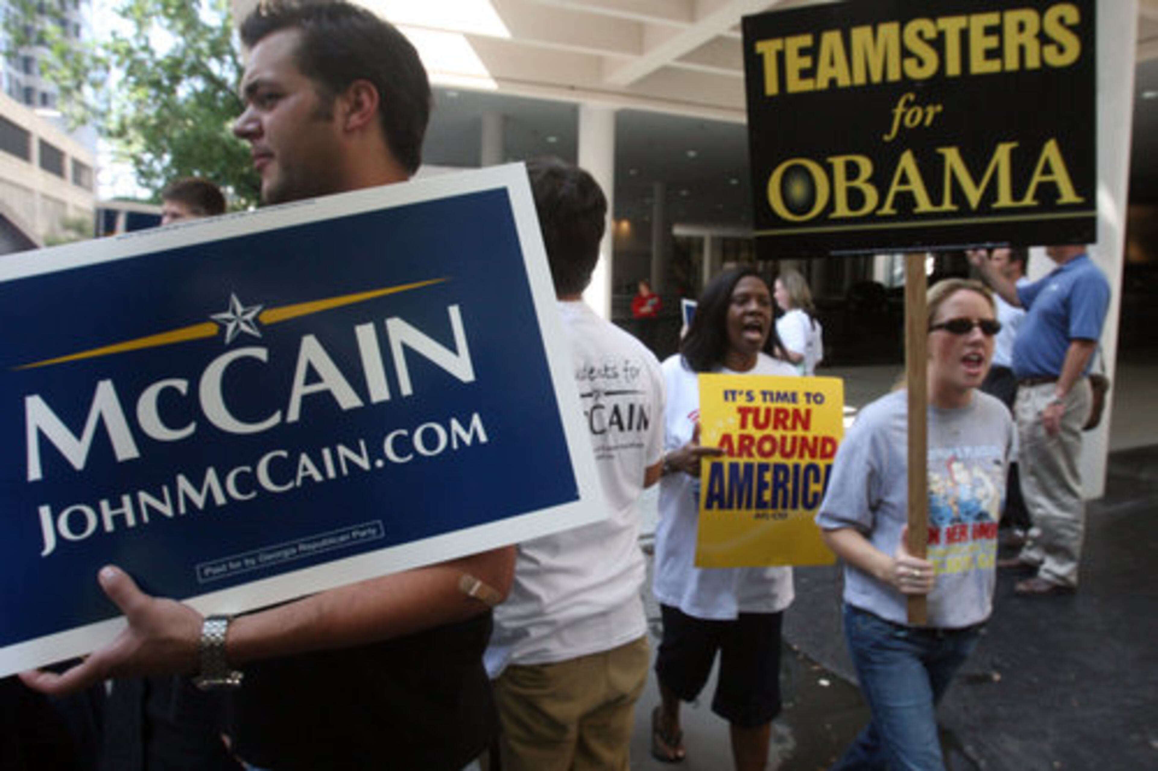 Topher Evans (left), a Georgia State student, show his support for McCain and Kim Ball of the Communications Workers of America and Renee Hinson of Teamsters 728 march against McCain along Peachtree Center Avenue in front of the Marriott Marquis in Atlanta.