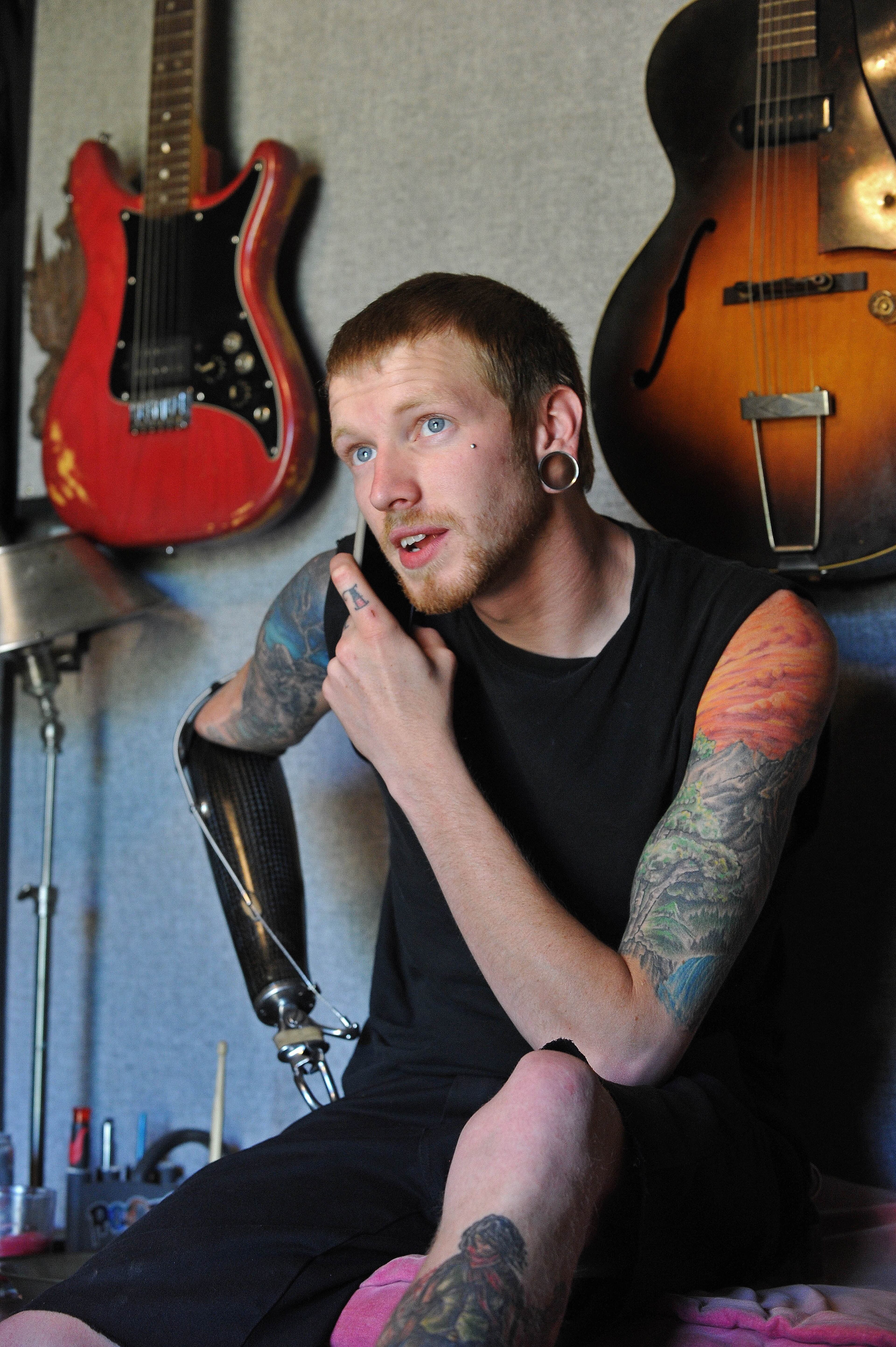 Aspiring musician Jason Barnes, a drummer who lost his right hand in an accident, relaxes at his house near a pair of his father's vintage guitars on Tuesday April 1, 2014 in Locust Grove, Ga. David Tulis / AJC Special