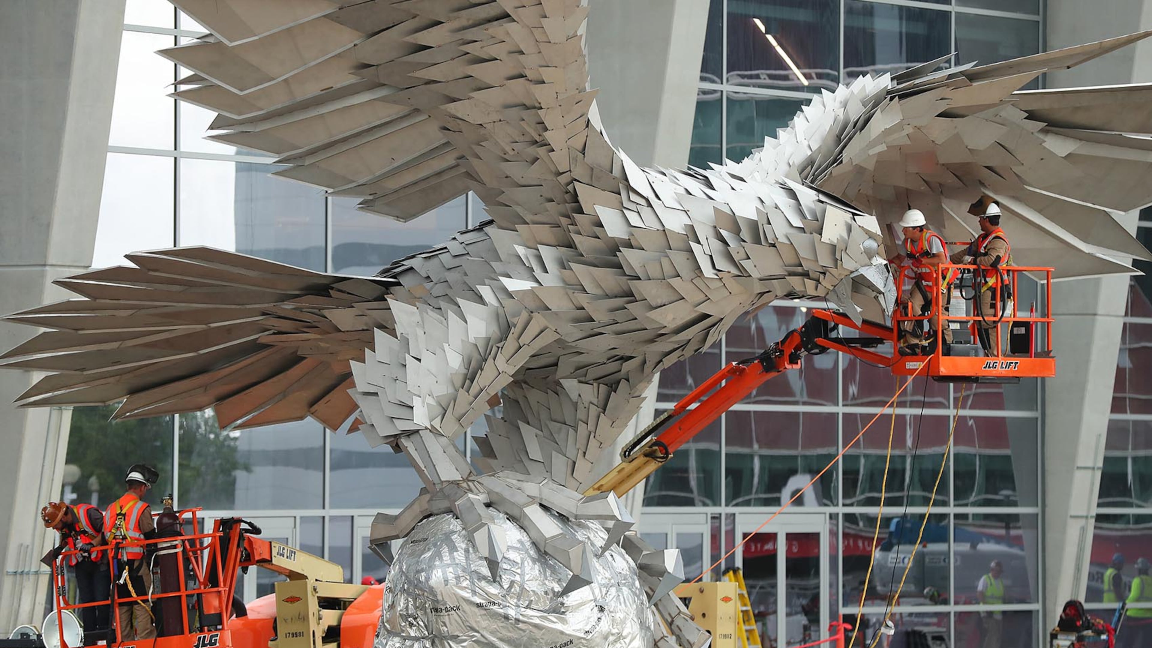 Workers install a 73,000-pound stainless steel sculpture of a falcon outside Mercedes-Benz stadium Thursday, April 27, 2017, in Atlanta.