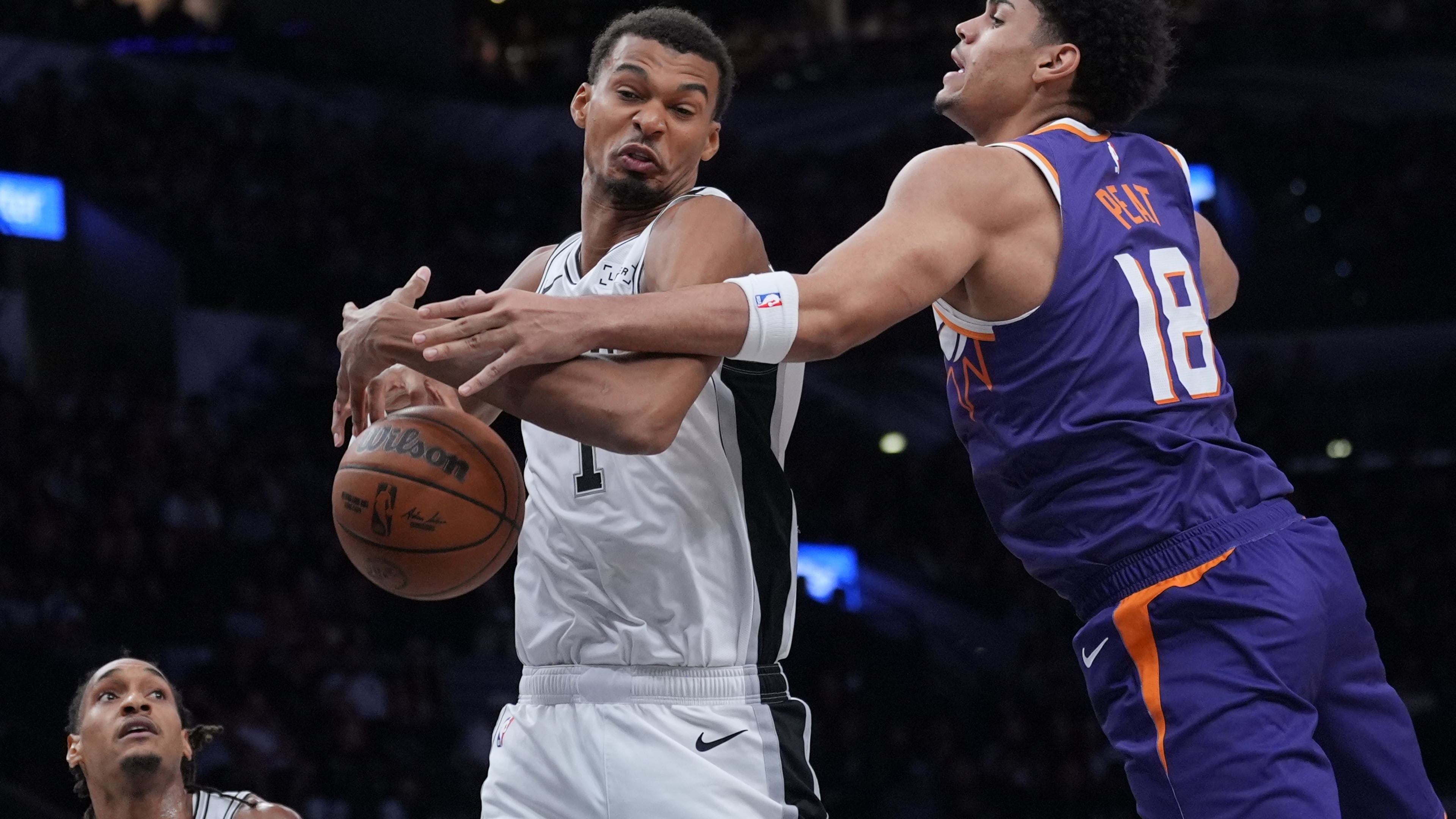 San Antonio Spurs forward Victor Wembanyama (1) and Phoenix Suns forward Koa Peat (18) battle for a rebound during the first half of a preseason NBA basketball game in San Antonio, Wednesday, Oct. 14, 2026. (AP Photo/Eric Gay)