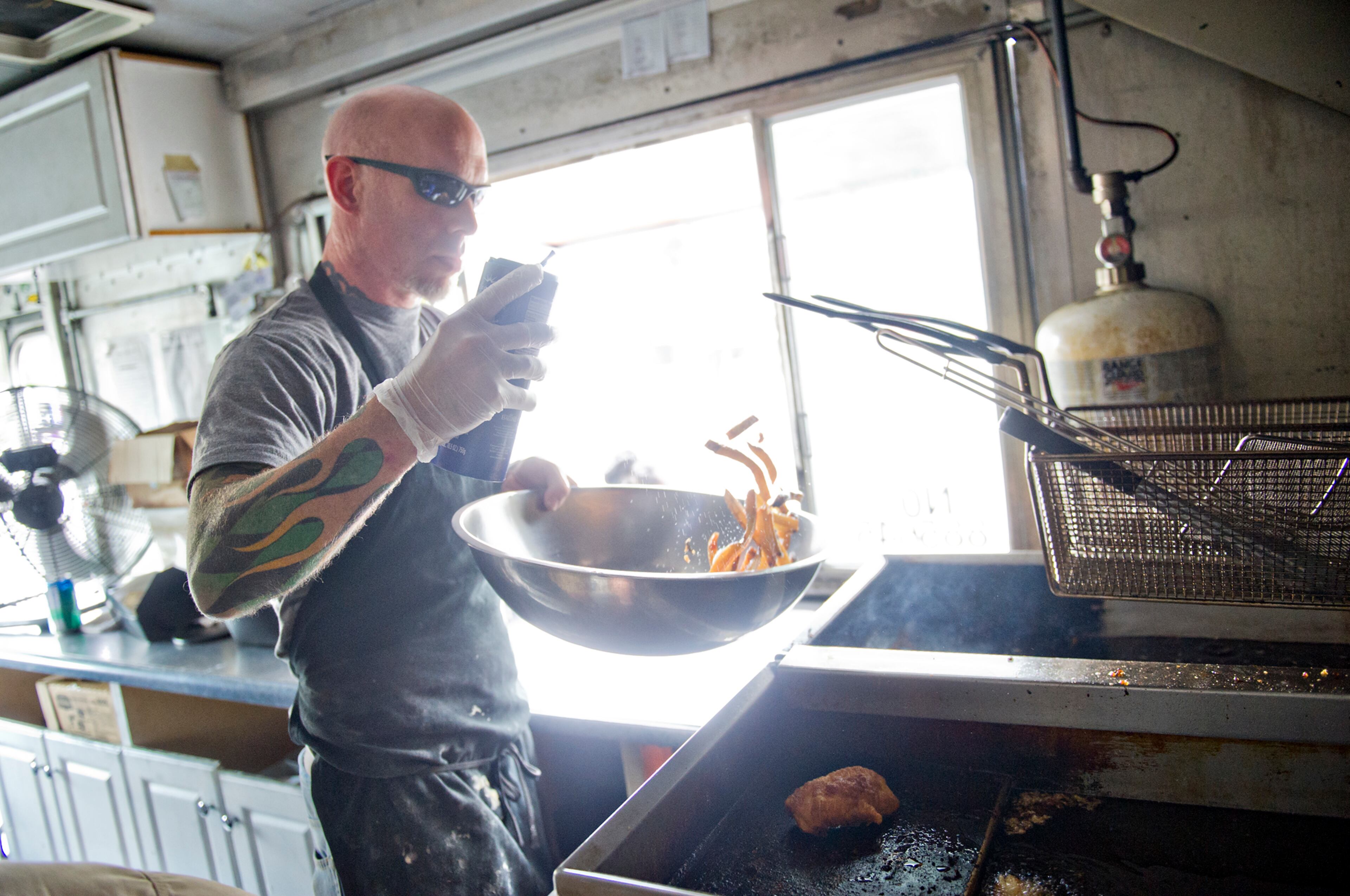 July 6, 2014 Marietta - Drew Verstraete seasons a bowl of fries inside the Mobile Marlay food truck during the Atlanta Food Festival at Jim R. Miller Park in Marietta on Sunday, July 6, 2014. JONATHAN PHILLIPS / SPECIAL