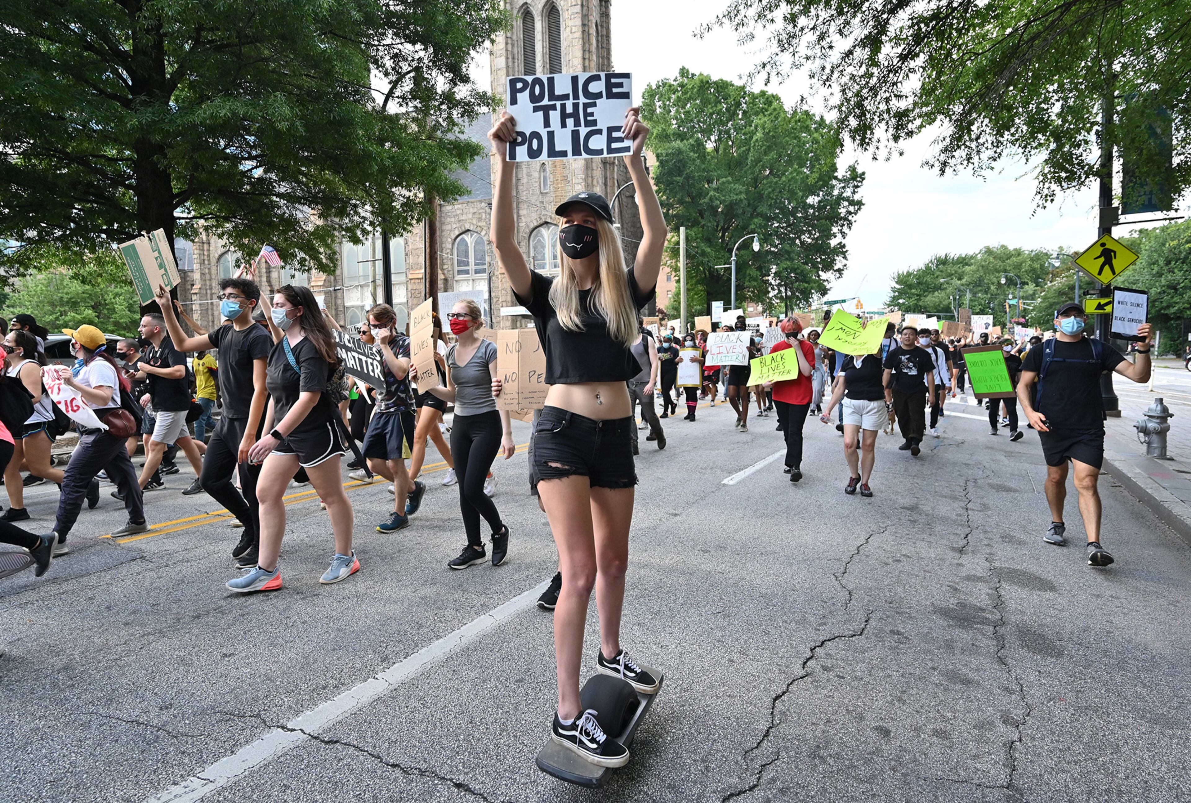 June 4, 2020 Atlanta - A protester holding a sign joins the march as she rides an Onewheel board on Peachtree Street during the seventh straight day of protest against police brutality and racism on Thursday, June 4, 2020. For the seventh straight day, metro Atlanta residents are gathering for a series of protests denouncing racism and police brutality and demanding change. Sparked by the deaths of George Floyd in Minneapolis, Ahmaud Arbery in Brunswick and Breonna Taylor in Louisville, demonstrations have filled the streets of downtown Atlanta since Friday. WednesdayâÃôs protests ended largely peacefully after the cityâÃôs curfew hit. A 9 p.m. curfew is in effect in Atlanta again Thursday. (Hyosub Shin / Hyosub.Shin@ajc.com)
