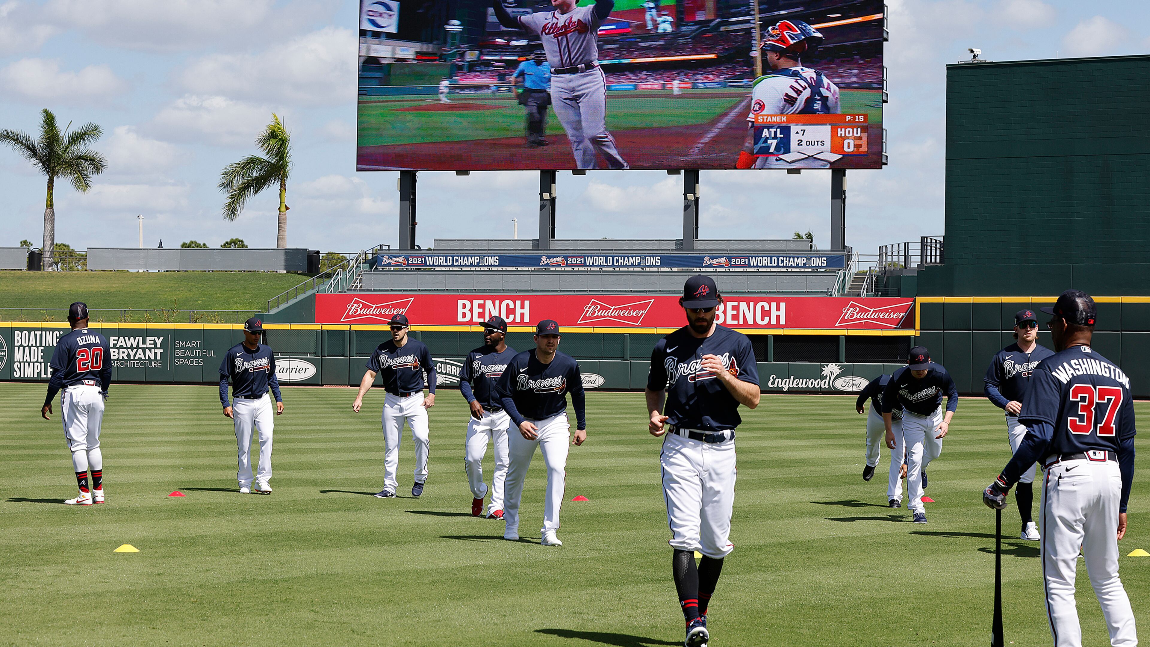 Braves first baseman Freddie Freeman is seen on the big screen rounding the bases on his home run during game six of the World Series while Dansby Swanson and the Braves loosen up in CoolToday Park during the first day of team practice at Spring Training on Monday, March 14, 2022, in North Port. “Curtis Compton / Curtis.Compton@ajc.com”`