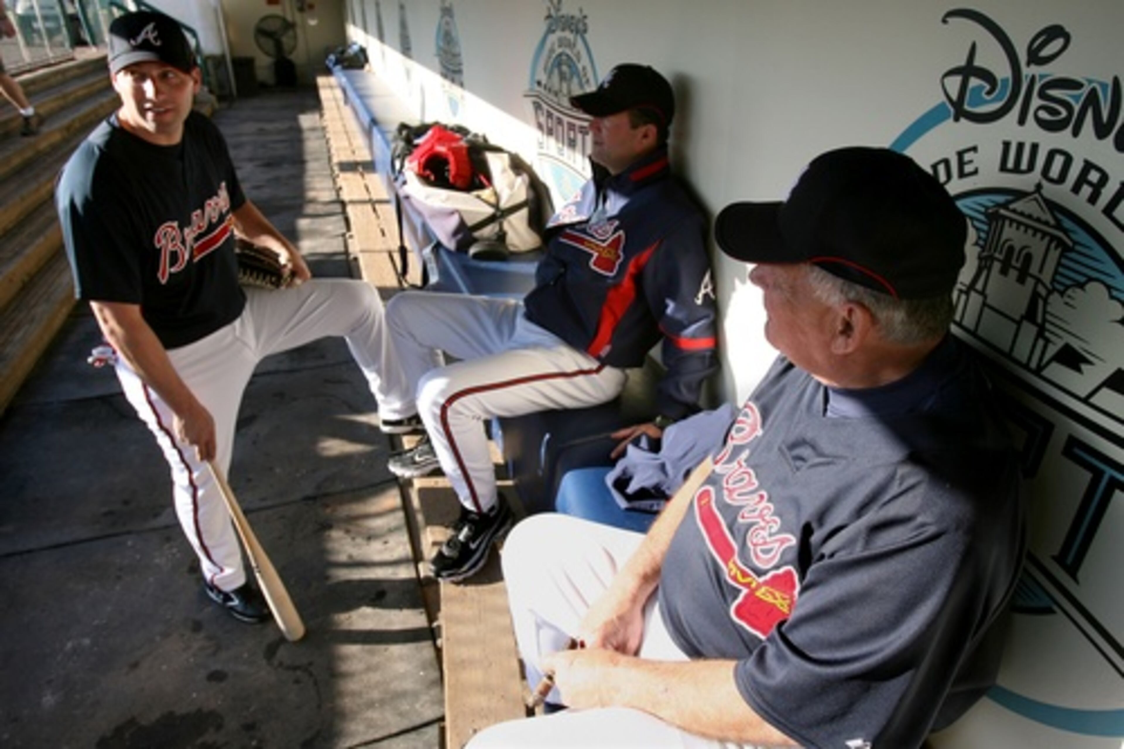 Right fielder Jeff Francoeur (from left), pitching coach Roger McDowell and manager Bobby Cox talk about golfing in the dug out during Day 2 of spring training camp at Champions Ballpark at Disney's Wide World of Sports Complex in Lake Buena Vista, Fla.