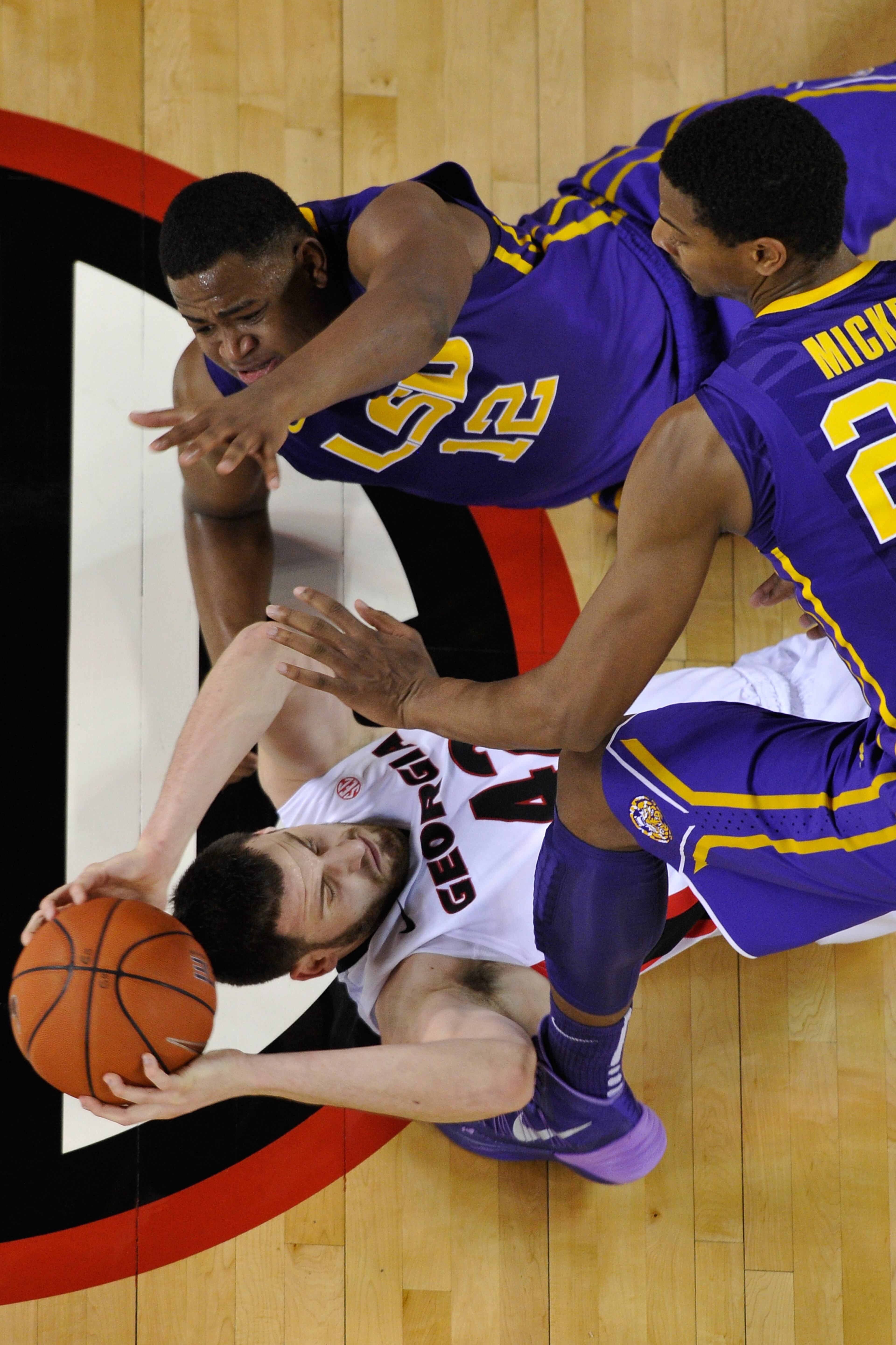 Georgia forward Nemanja Djurisic (42) grabs a loose ball while defended by LSU forward Jarell Martin (12) and LSU forward Jordan Mickey (25) during the first half of the NCAA college basketball game on Thursday, Feb. 6, 2014 in Athens, Ga. (AP Photo/Athens Banner-Herald, AJ Reynolds)