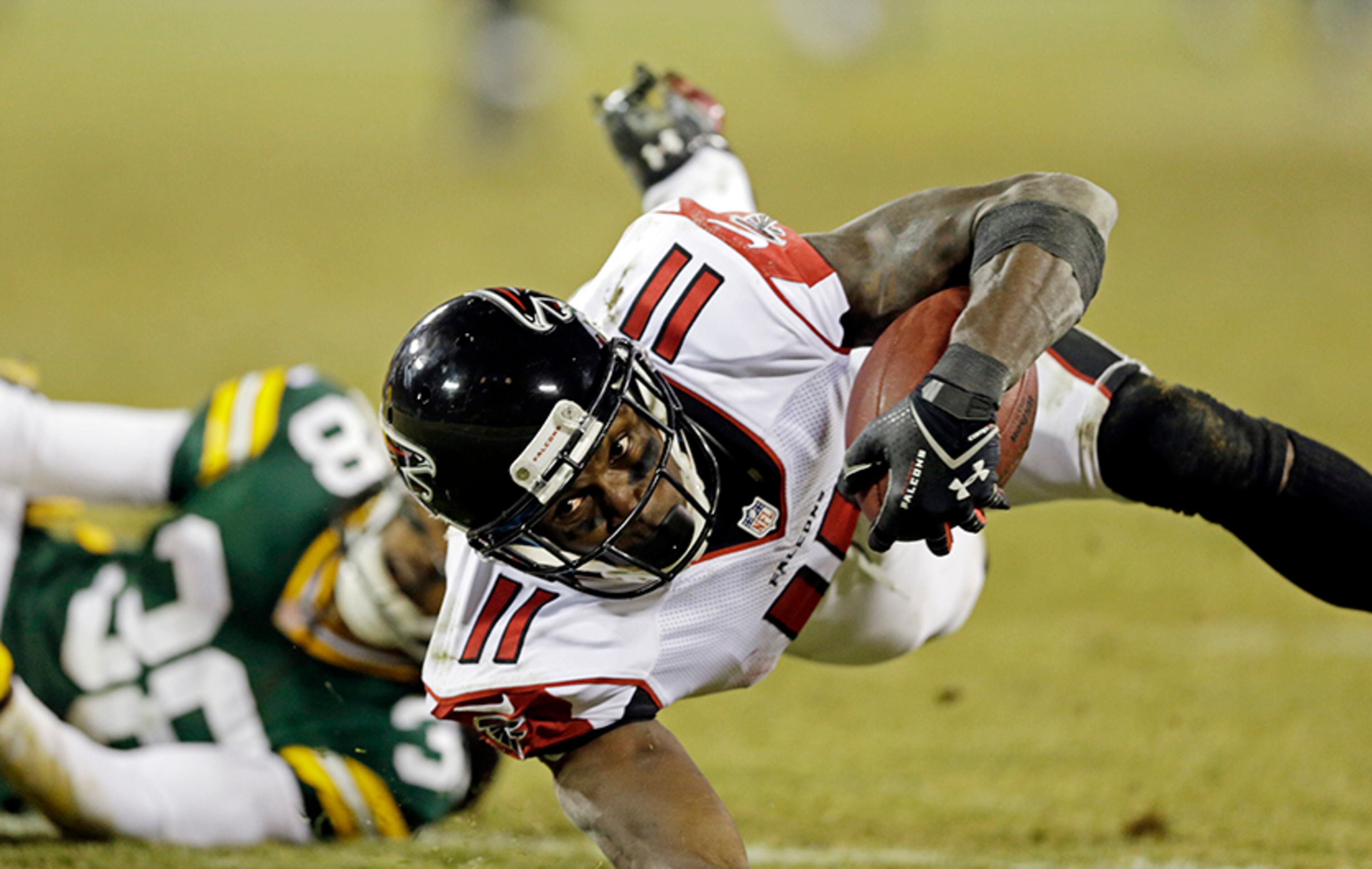 Atlanta Falcons' Julio Jones is tripped up by Green Bay Packers' Tramon Williams after a catch during the second half Monday, Dec. 8, 2014, in Green Bay, Wis.