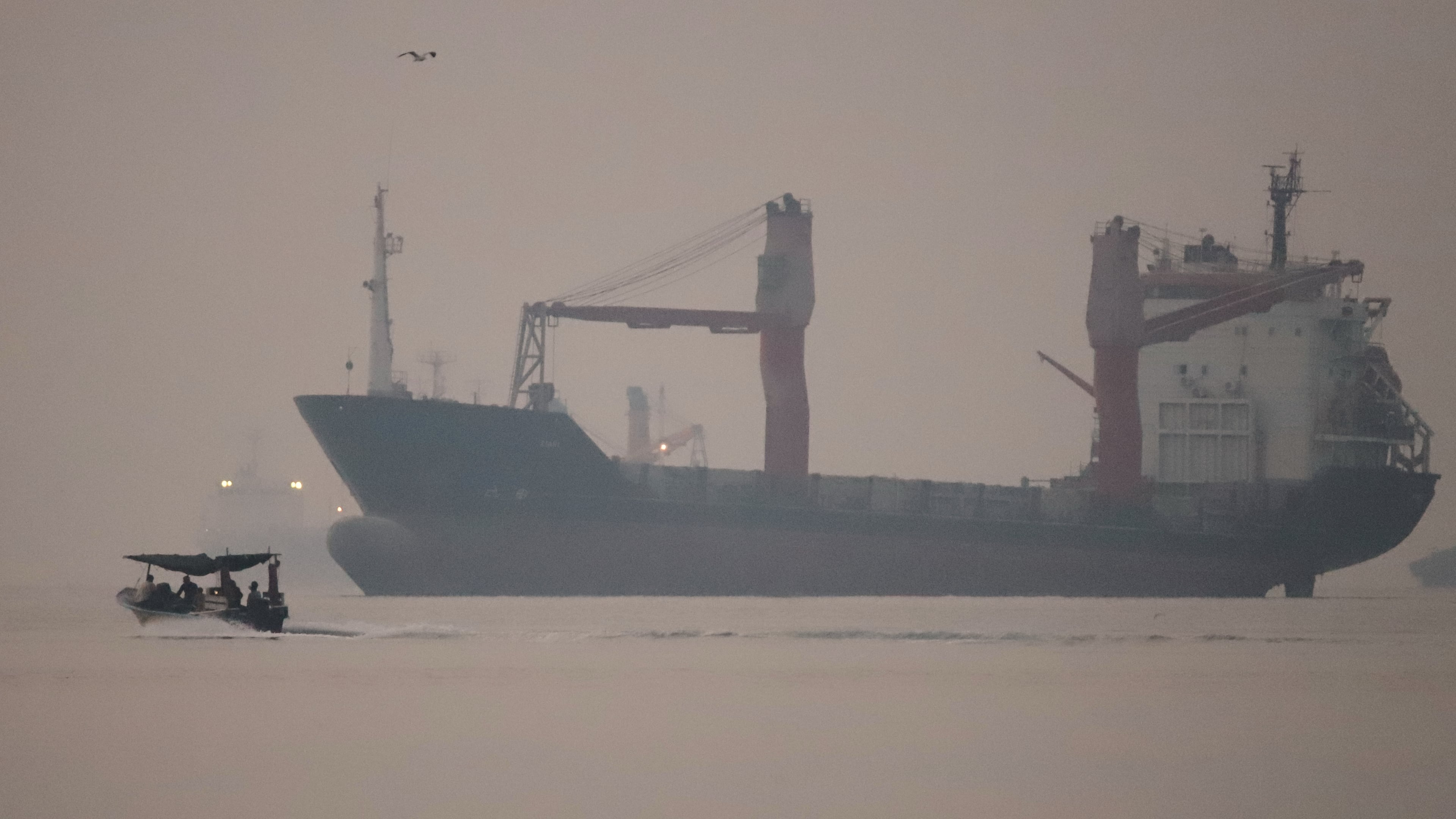 A motorboat passes an anchored cargo ship in the Strait of Hormuz off Bandar Abbas, Iran, early Monday, Sept. 28, 2026. (Amirhosein Khorgooi/ISNA via AP)