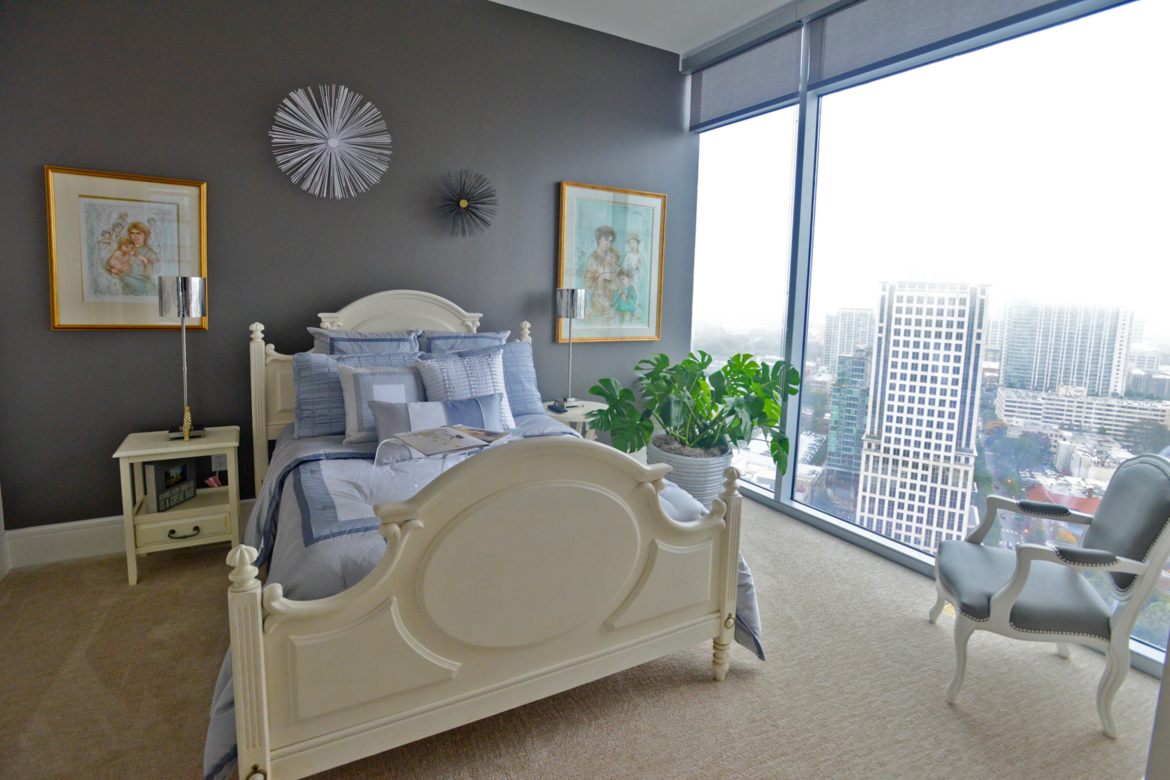 Guests in Jim Wilson's home are always given a room with a view. Depending on the weather, they can enjoy the city lights of Atlanta or feel like they are sleeping in the clouds. The bedding is from Macy's Hotel Collection.