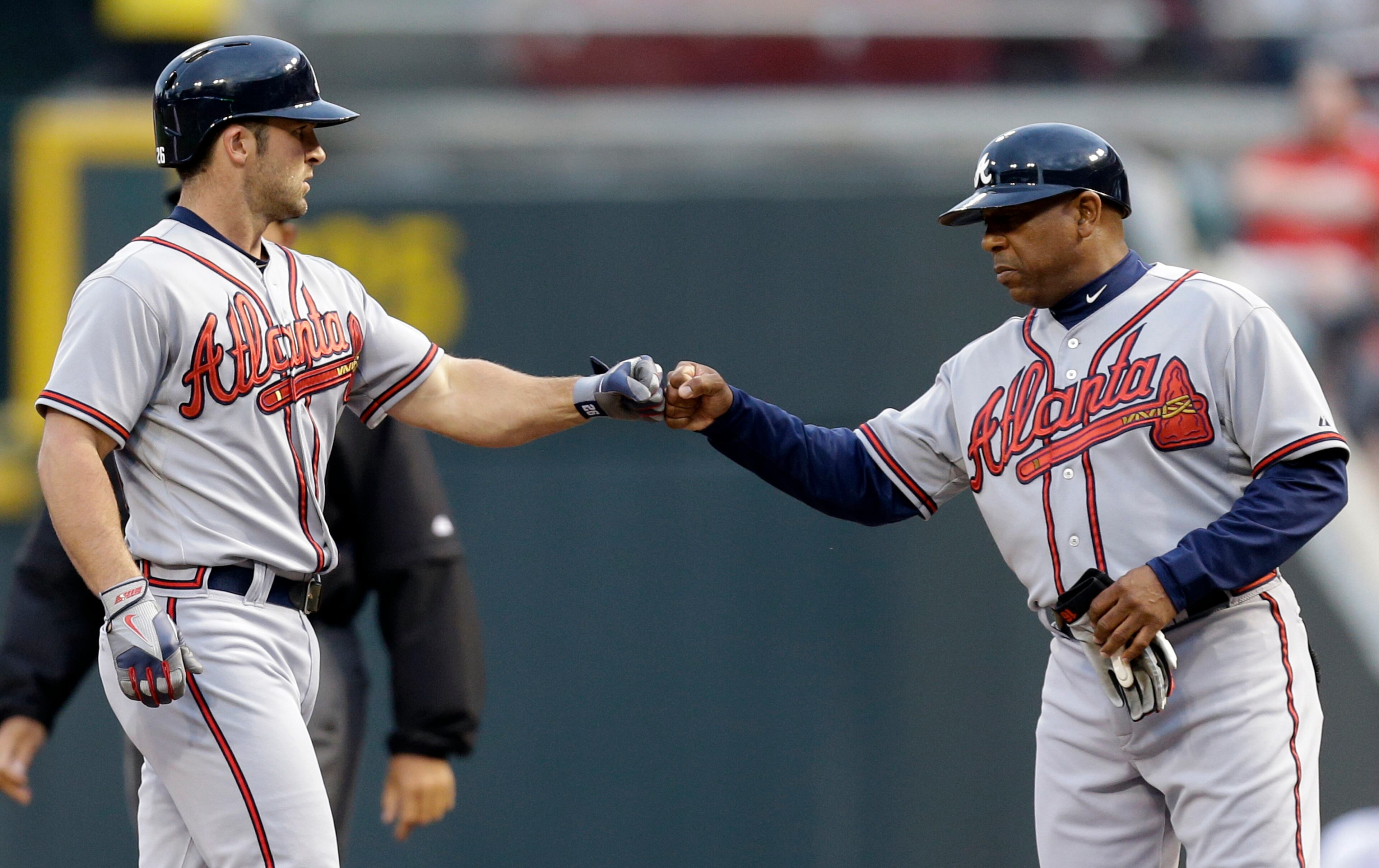 Braves' Dan Uggla, left, is congratulated by first base coach Terry Pendleton after Uggla drove in a run in the first,