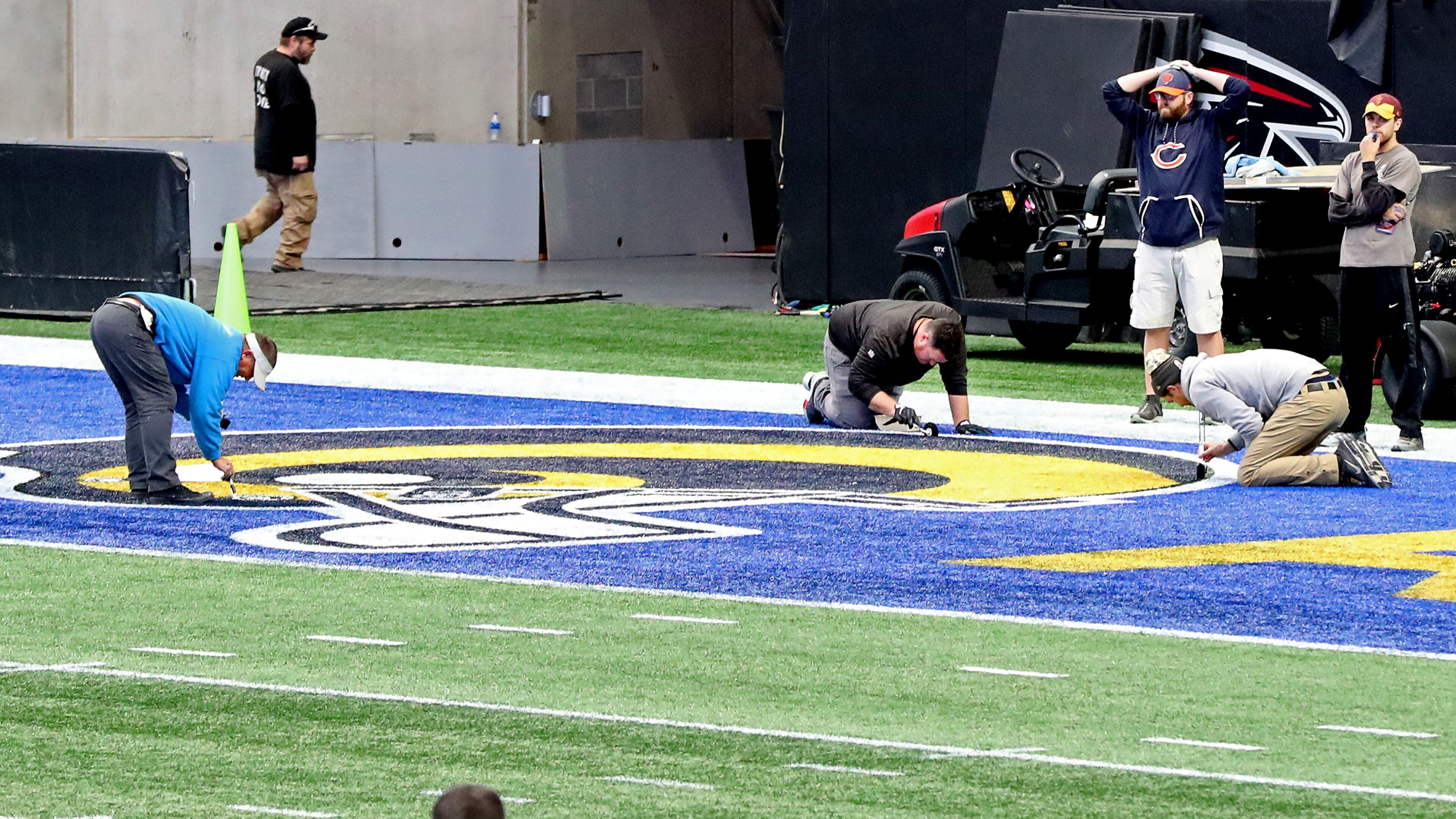 Workers painted the Los Angeles Rams logo in one end zone at Mercedes-Benz Stadium in preparation for the Super Bowl.