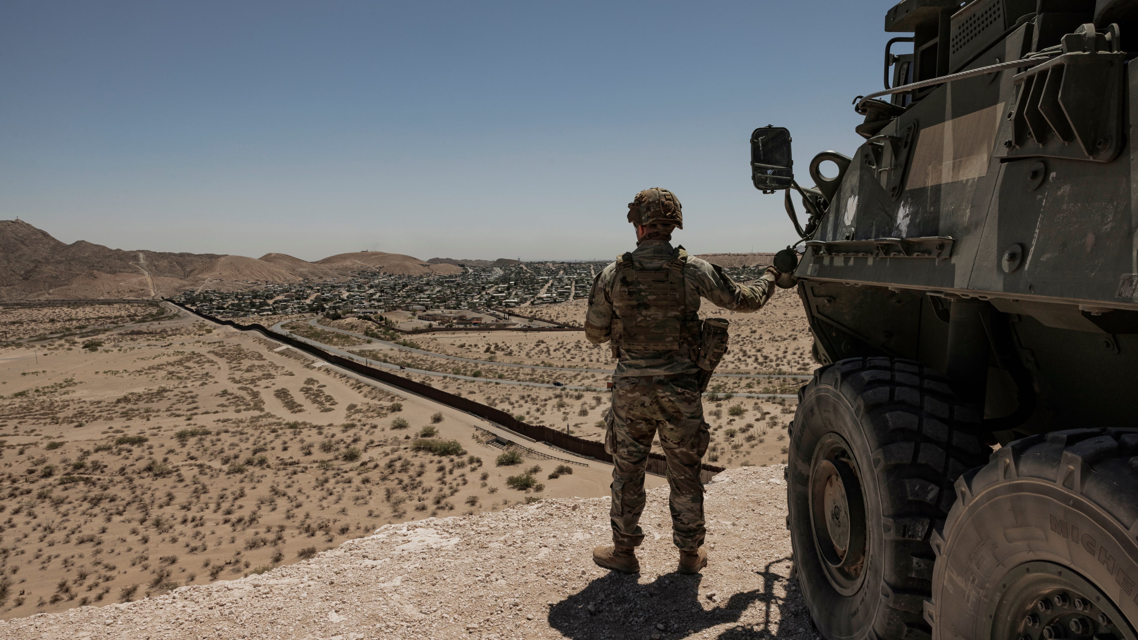A U.S. soldier watches the southern border from a high vantage point near Santa Teresa, New Mexico, on April 12, 2025. Georgia was the seventh most popular destination in the country for migrants who made their way to the U.S.-Mexico border amid an unprecedented surge in arrivals. (Adriana Zehbrauskas/The New York Times)