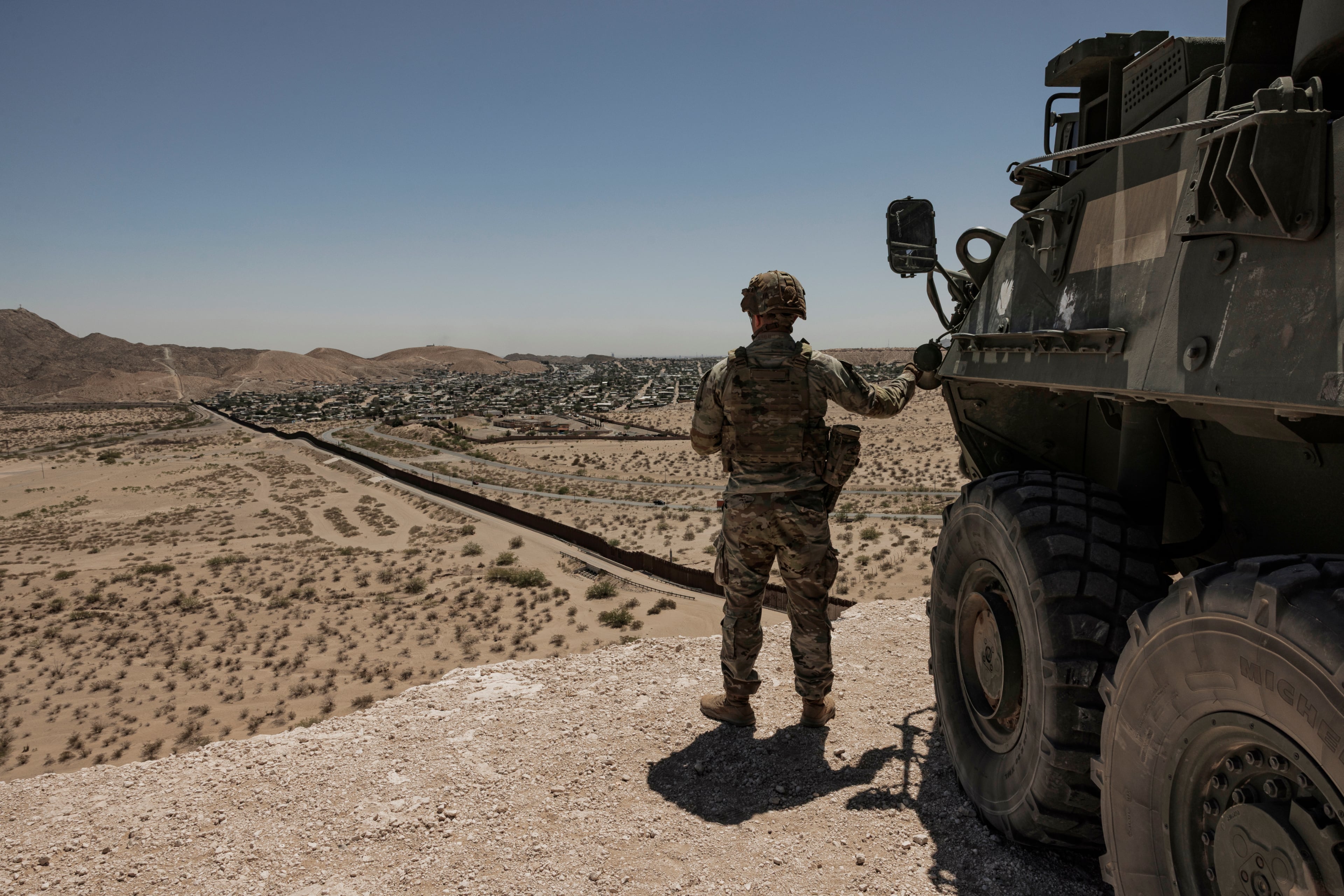 A U.S. soldier watches the southern border from a high vantage point near Santa Teresa, New Mexico, on April 12, 2025. Georgia was the seventh most popular destination in the country for migrants who made their way to the U.S.-Mexico border amid an unprecedented surge in arrivals. (Adriana Zehbrauskas/The New York Times)