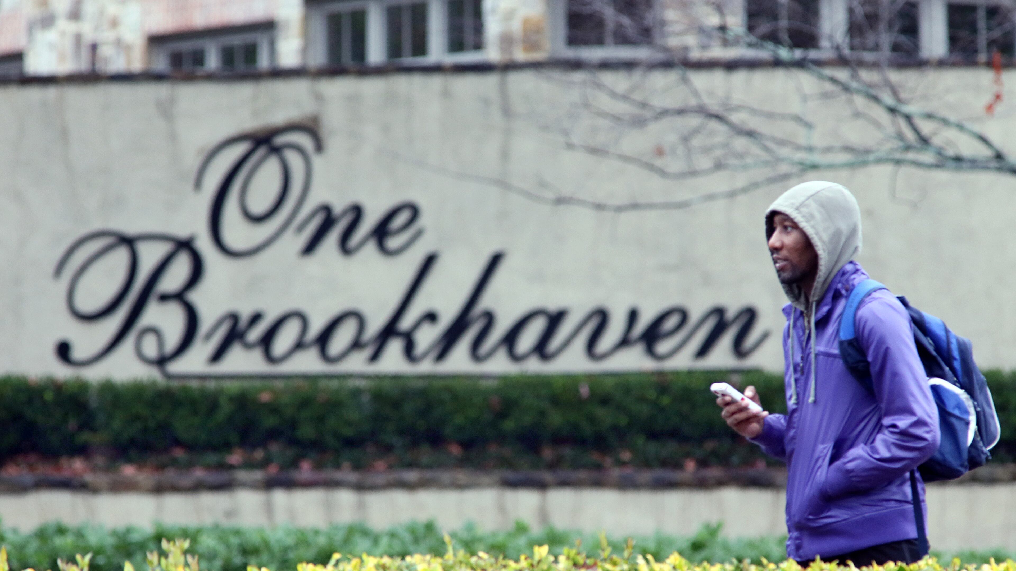 Brenton Etuk walks pass a Brookhaven sign on Peachtree Rd. on his way to work in Buckhead. Brookhaven on Monday, December 17, 2012, officially became DeKalb County’s largest and Georgia’s newest city.