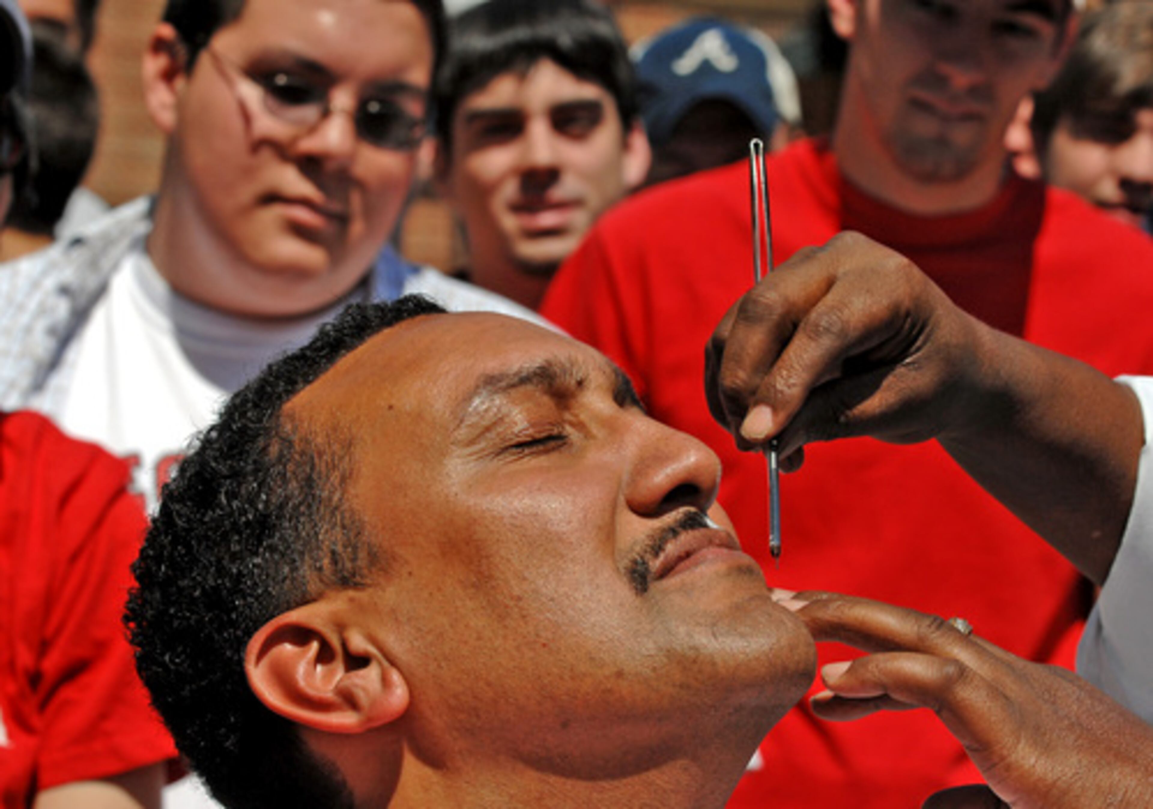 UGA men's SEC-winning basketball coach Dennis Felton gets his mustache shaved off Friday outside the Tate Student Center in Athens. Felton promised to shave if the Dogs won a championship - they did, and he did.