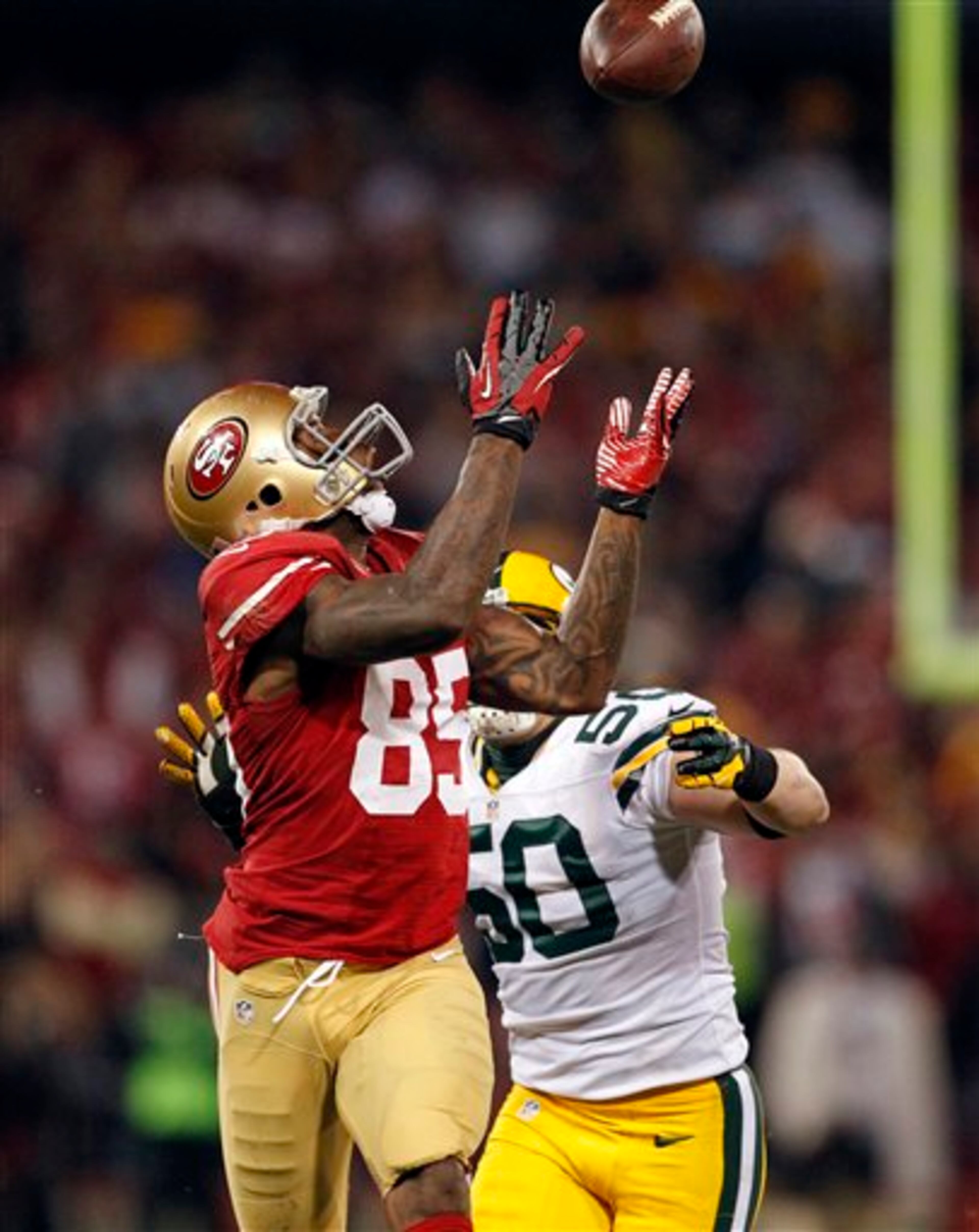 San Francisco 49ers tight end Vernon Davis (85) catches a pass over Green Bay Packers inside linebacker A.J. Hawk (50) during the third quarter of an NFC divisional playoff NFL football game in San Francisco, Saturday, Jan. 12, 2013. (AP Photo/Tony Avelar)