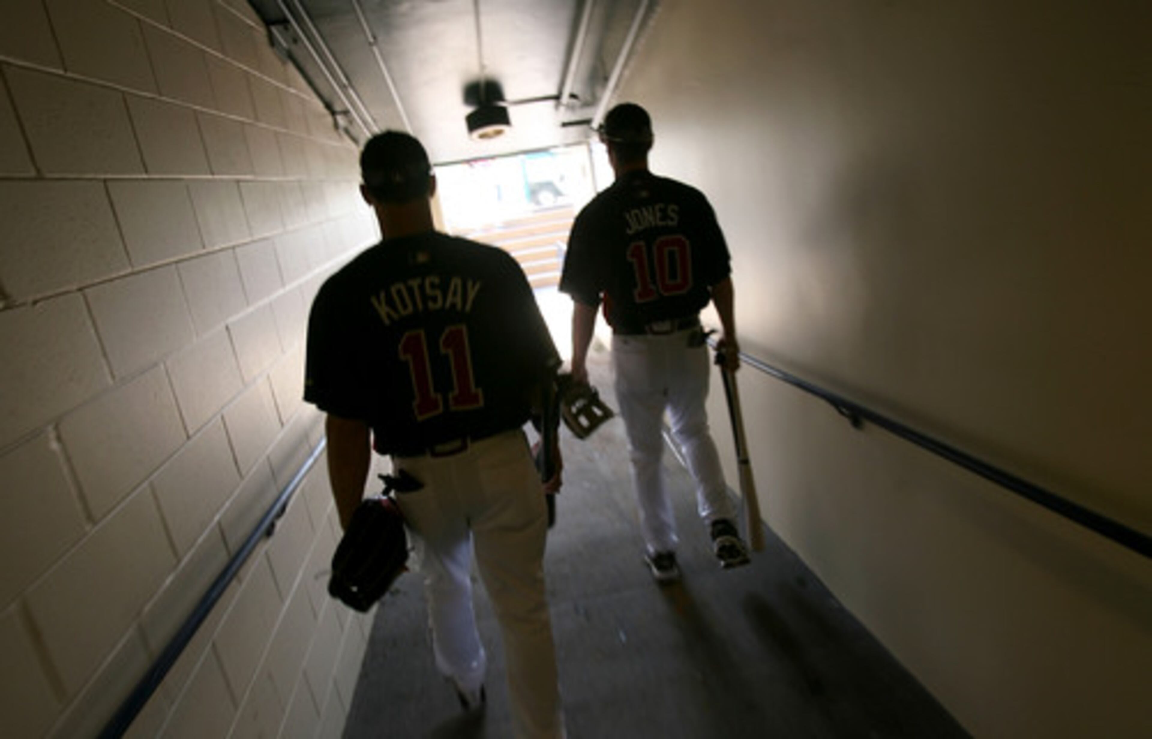 Mark Kotsay and Chipper Jones make their way to the field during day three of spring training at Champions Ballpark Sunday.