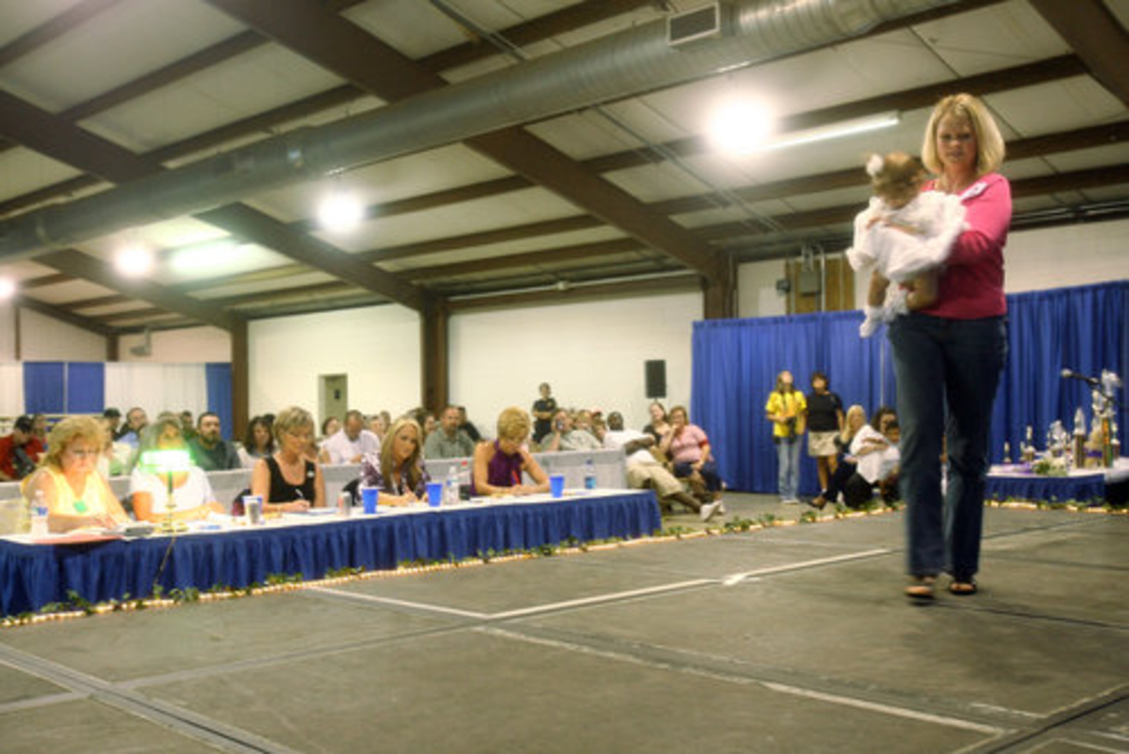 Wendy Dickey and her daughter Paisley Scott Dickey, 9 months, depart the stage in front of the pageant judges. A series of pageants will be held at the fair. The winner of the Miss Gwinnett County pageant will be entered in the Miss Georgia pageant in June 2009.