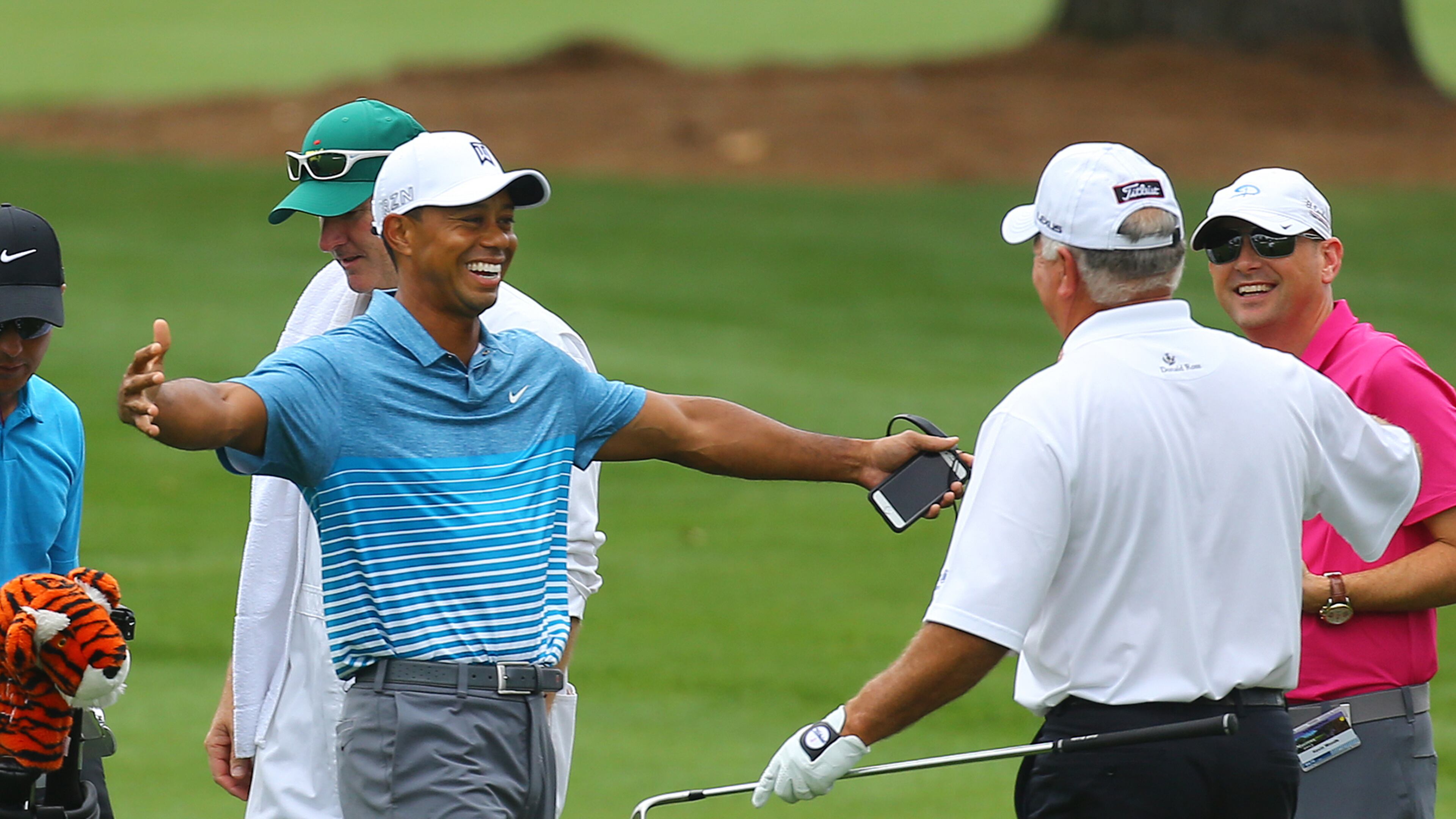 Tiger Woods opens his arms to hug Mark O’Meara as he arrives at the Augusta National Golf Club practice range for the Masters on Monday, April 6, 2015, in Augusta. Curtis Compton / ccompton@ajc.com