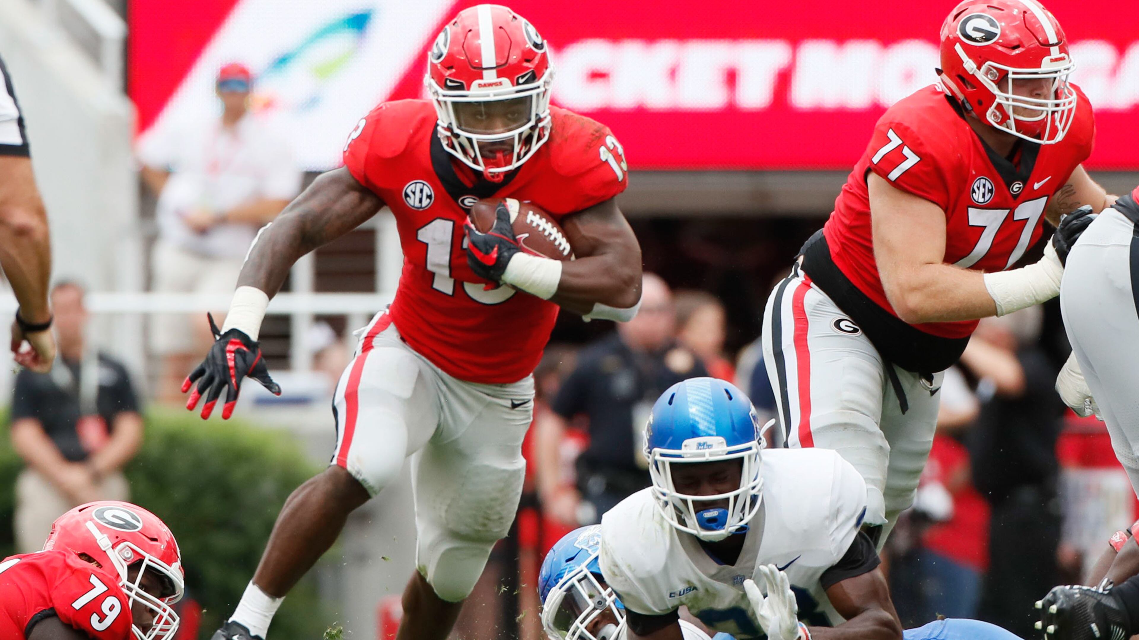 The Bulldogs offensive line supplies the daylight Saturdy and running back Elijah Holyfield makes the most of it. (BOB ANDRES /BANDRES@AJC.COM)