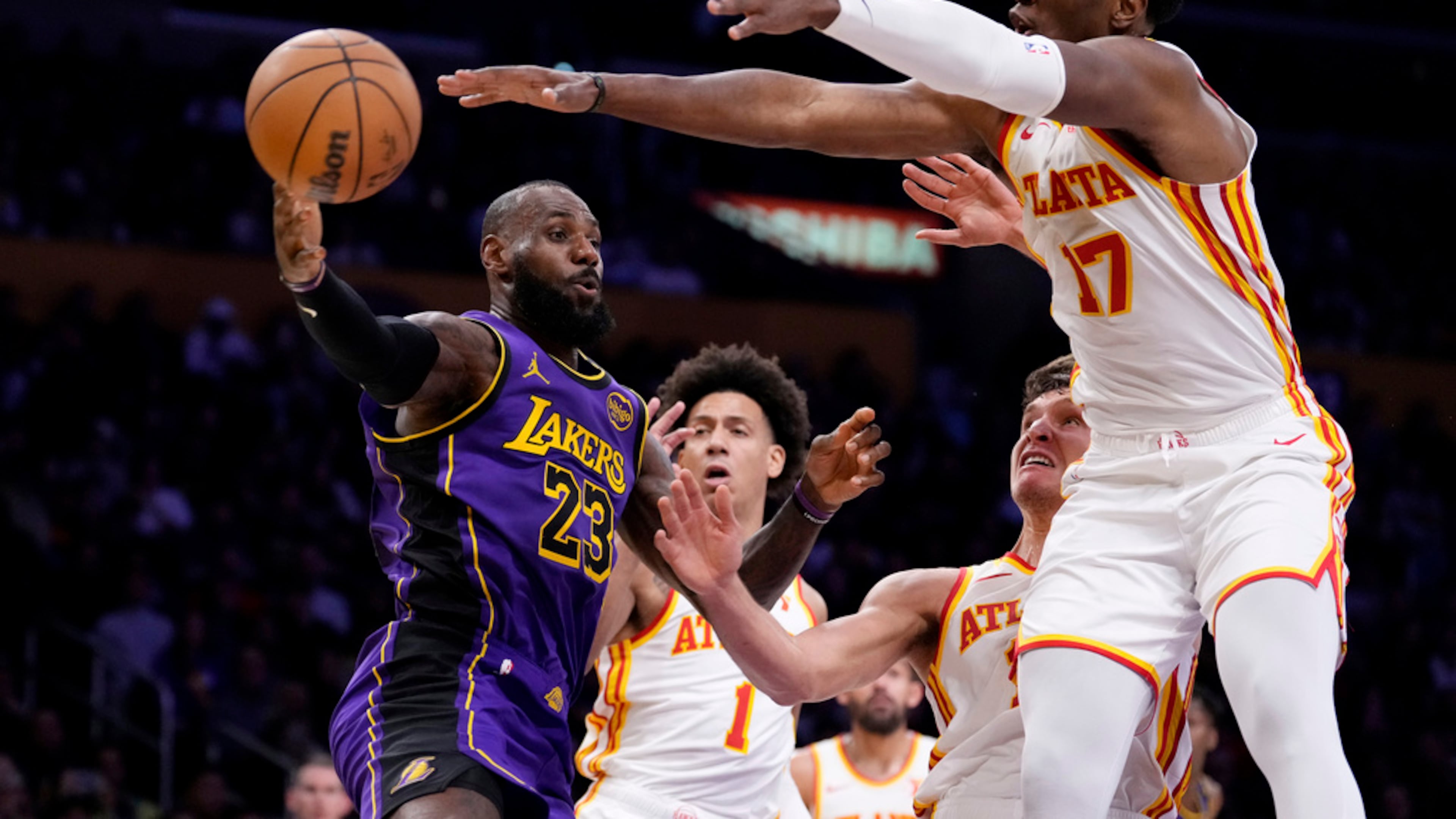 Los Angeles Lakers forward LeBron James, left, passes the ball as Atlanta Hawks forward Jalen Johnson, second from left, guard Bogdan Bogdanovic, second from right, and forward Onyeka Okongwu defend during the first half of an NBA basketball game, Friday, Jan. 3, 2025, in Los Angeles. (Mark J. Terrill/AP)
