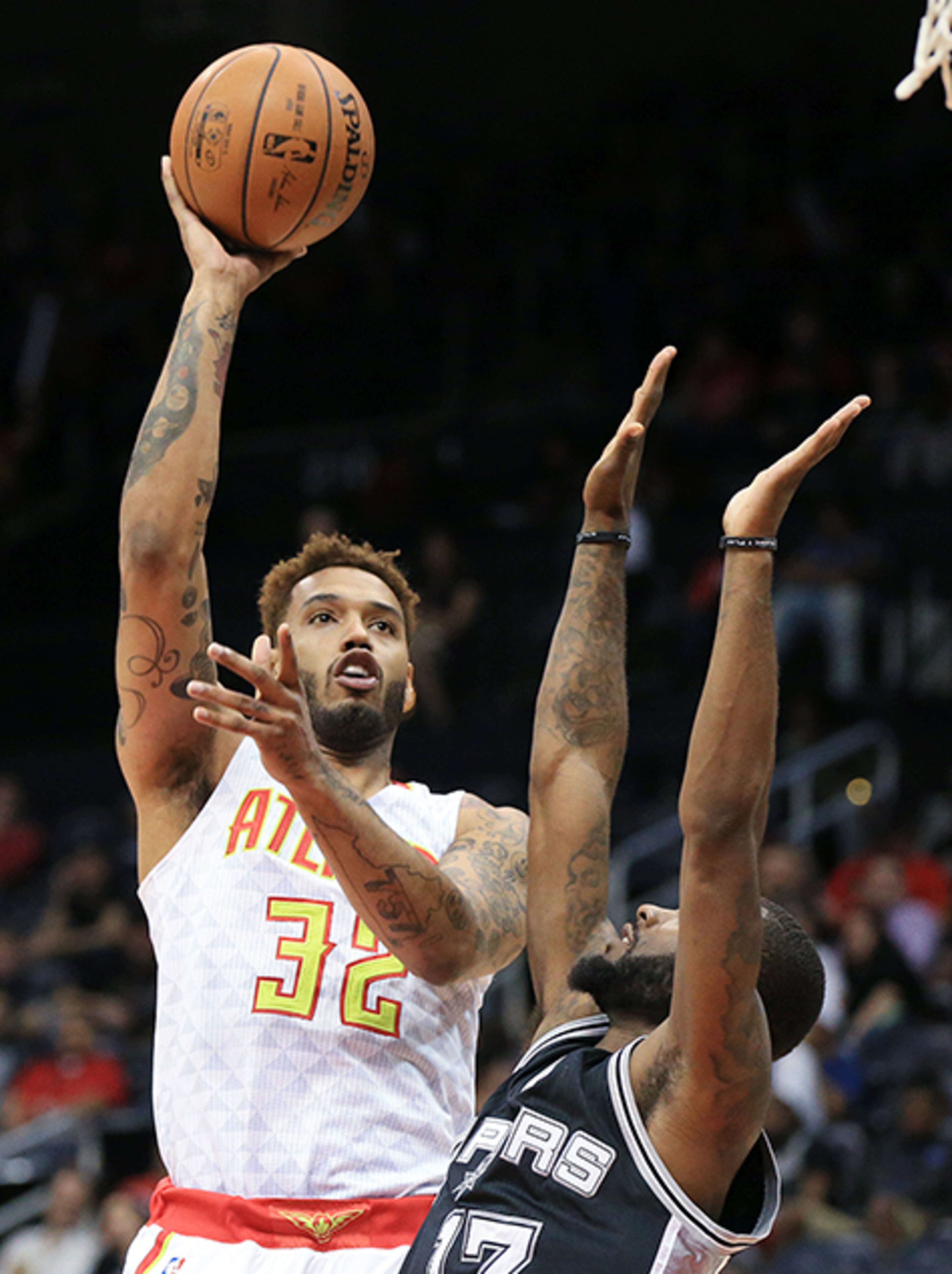 Hawks forward Mike Scott puts up two over the Spurs' Jonathan Simmons during the second half of their preseason matchup Wednesday, Oct. 14, 2015, in Atlanta.