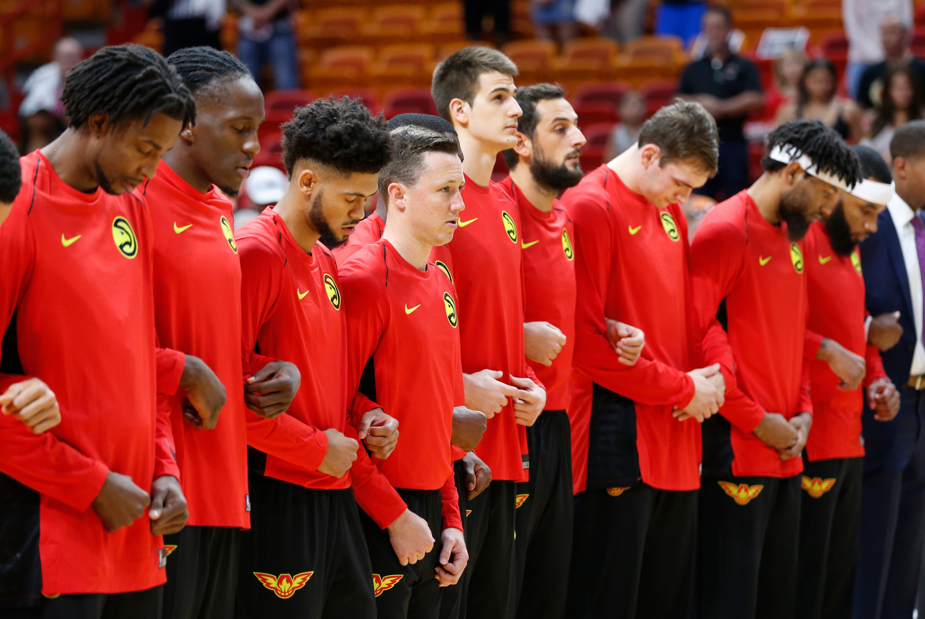 Hawks players link arms during the singing of the National Anthem before the start of a preseason game against the Miami Heat, Sunday, Oct. 1.