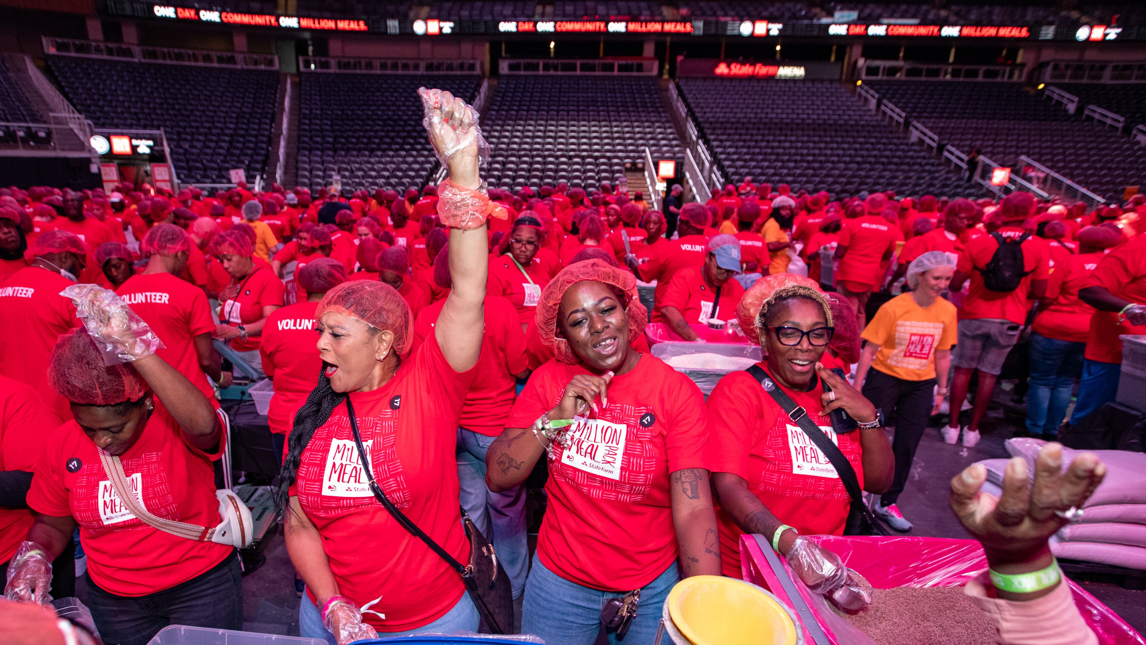 Monica Stokes (from left), Bonica Franklin, Carri Washington and Lashaunda Easley take a dance break from packing jambalaya kits during last year's event. This year's fifth annual Million Meal Pack takes place Sept. 27. (Jenni Girtman for the AJC)