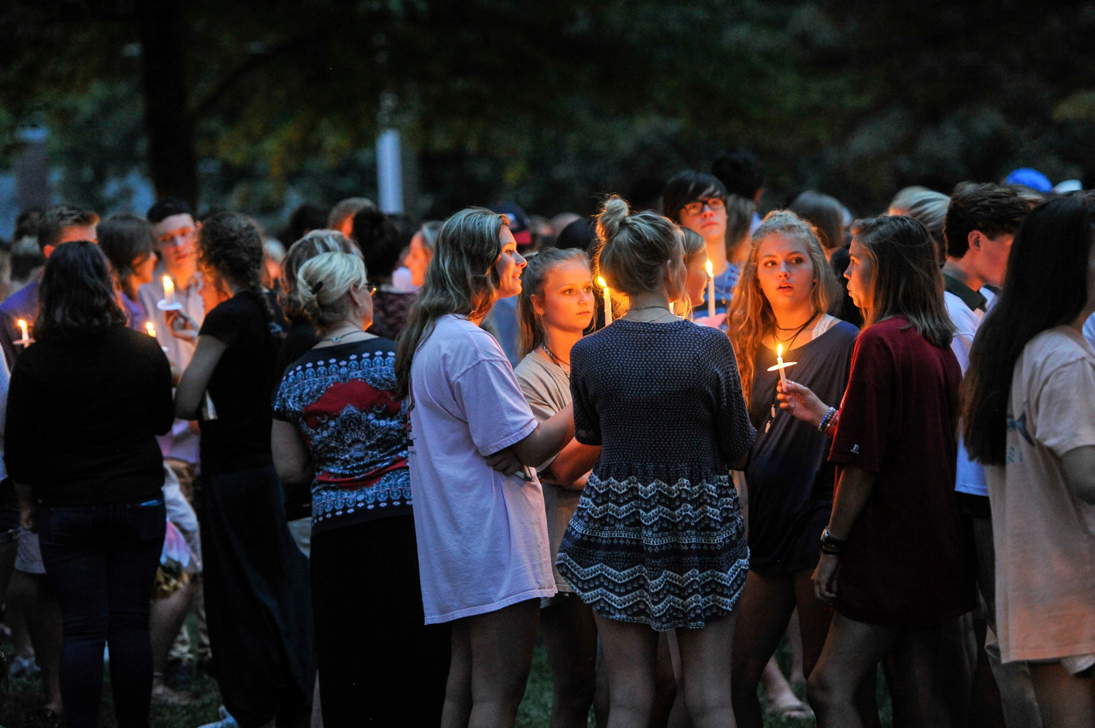 Friends of Natalie Henderson hug during a vigil held for her on the old Roswell Square, Thursday, Aug. 4, 2016. Henderson, of Roswell, and Carter Davis of Woodstock, both 17, were found Monday, Aug. 1, 2016, behind a Publix, grocery store shot to death. Jeffrey A. Hazelwood, 20, was arrested Wednesday and will be charged with two counts of murder in the deaths. (Photo Contributed by John Amis)