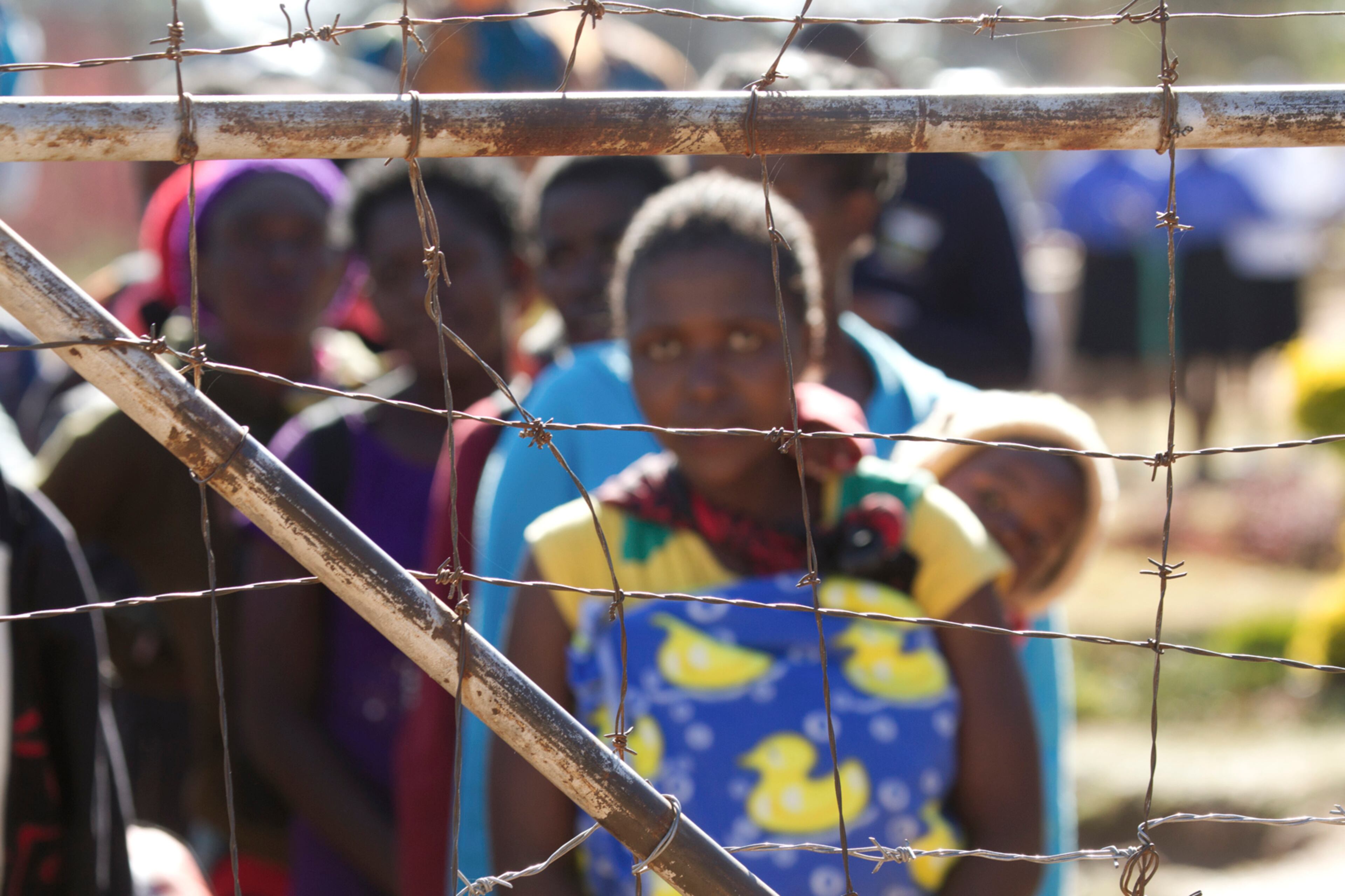 Malawians wait to be released from Chikurubi Maximum Prison on the outskirts of Harare, Tuesday, June, 27, 2017. Zimbabwean prison authorities repatriated 83 Malawians who had been serving time for various crimes in the country's prisons. Many of the prisoners expressed relief leaving the prison where living conditions are dire and food shortages are routine. The prisoners travelled by bus back to their home country. (AP Photo/Tsvangirayi Mukwazhi)