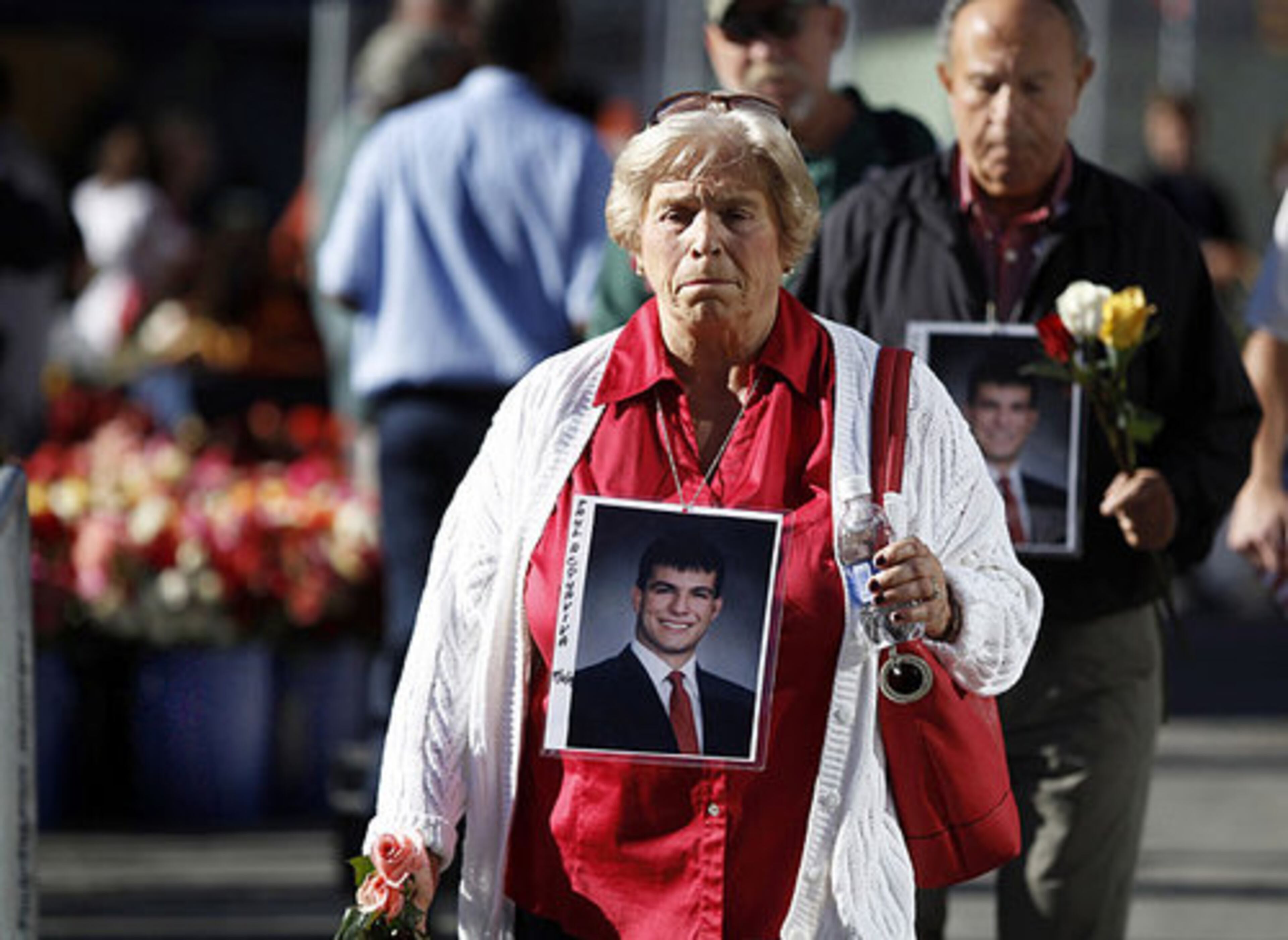 Mourners carrying photos of Paul Acquaviva, who died in the Sept. 11 terrorist attacks on the World Trade Center, walk into the heart of ground zero during a ceremony marking the ninth anniversary of the attacks Saturday, Sept. 11, 2010 in New York.