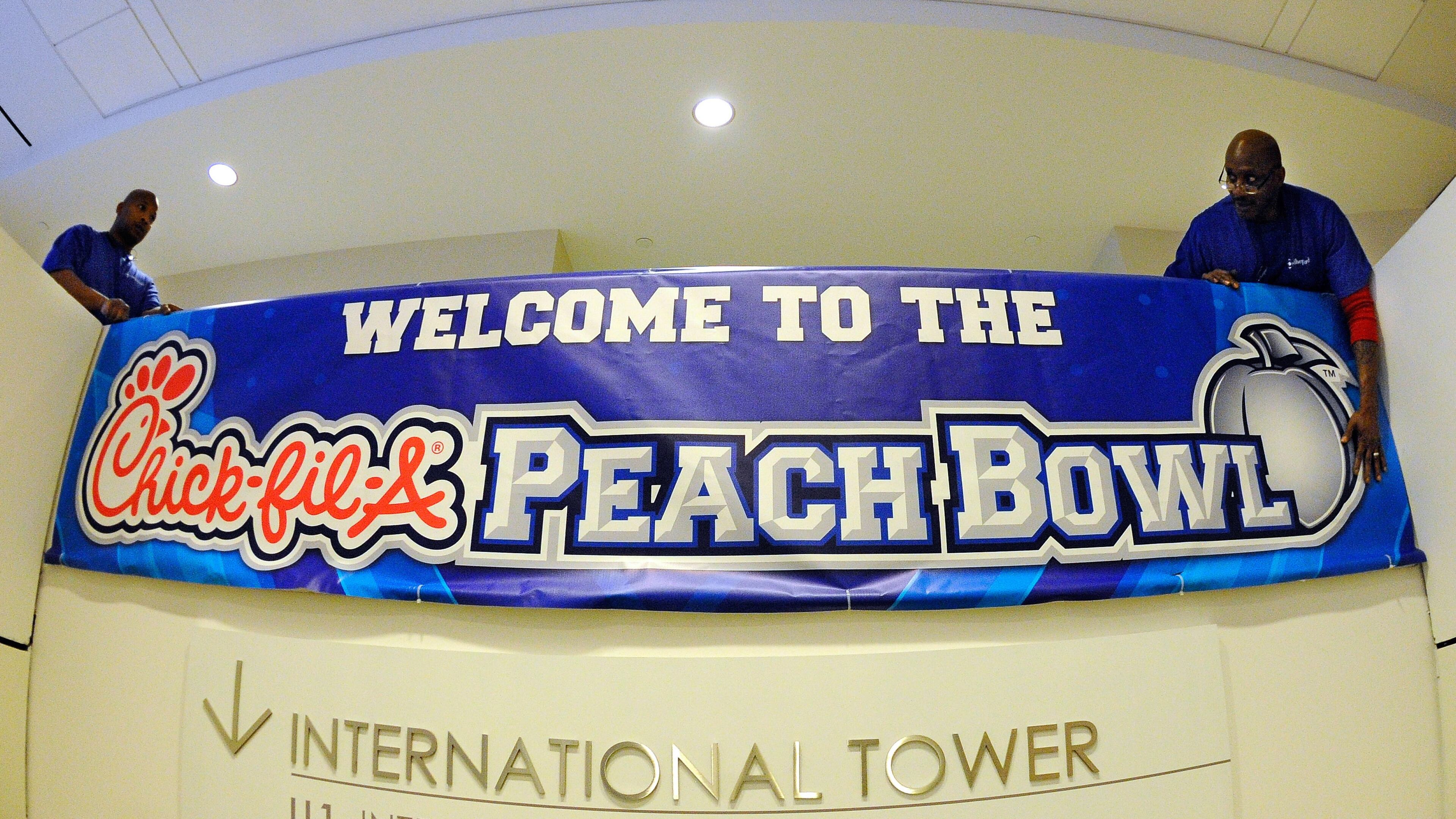 Tim Burson, left, and Eddie Cofer position a welcome sign for guests at the Hyatt Regency Hotel attending the Chick-fil-A Peach Bowl game on Friday, Dec. 26, 2014, in Atlanta. Bowl Week begins with welcome parties for the No. 9 Ole Miss and No. 6 TCU college football teams Friday evening from 6:30 p.m. - 8:00 p.m. at the new College Football Hall of Fame and the game's kickoff is at 12:30 p.m. on New Year's Eve at the Georgia Dome. David Tulis/AJC Special