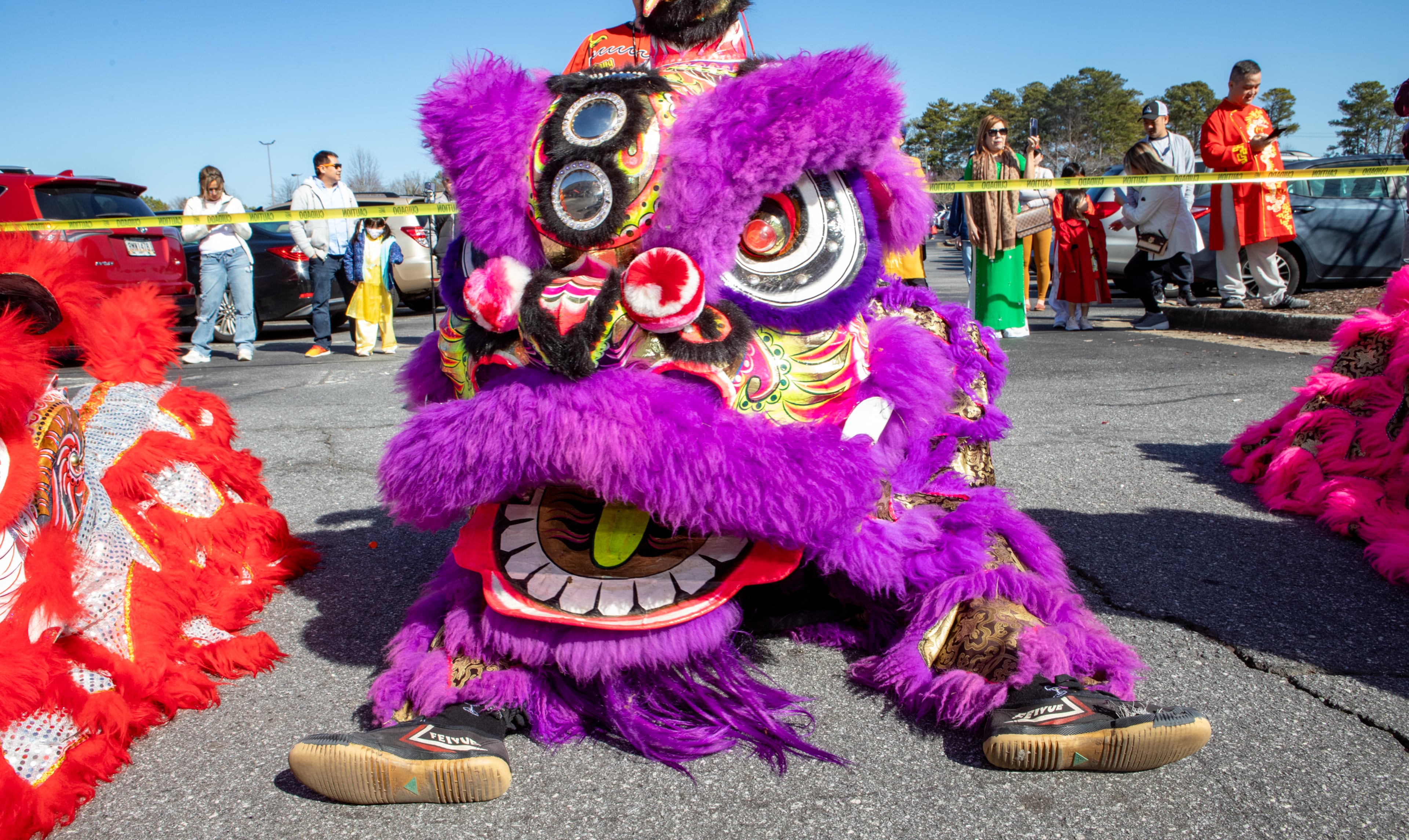 Lion dancers wait and watch the ribbon cutting before they continue their dance on Saturday, Feb 3, 2024. The Vietnamese American Community of Georgia hosts a Lunar New Year celebration at Plaza Las Americas in Lilburn on where dragon and lion dancing begins the weekend. The celebration continues on Sunday and includes traditional food, music and cultural festivities. (Jenni Girtman for The Atlanta Journal-Constitution)