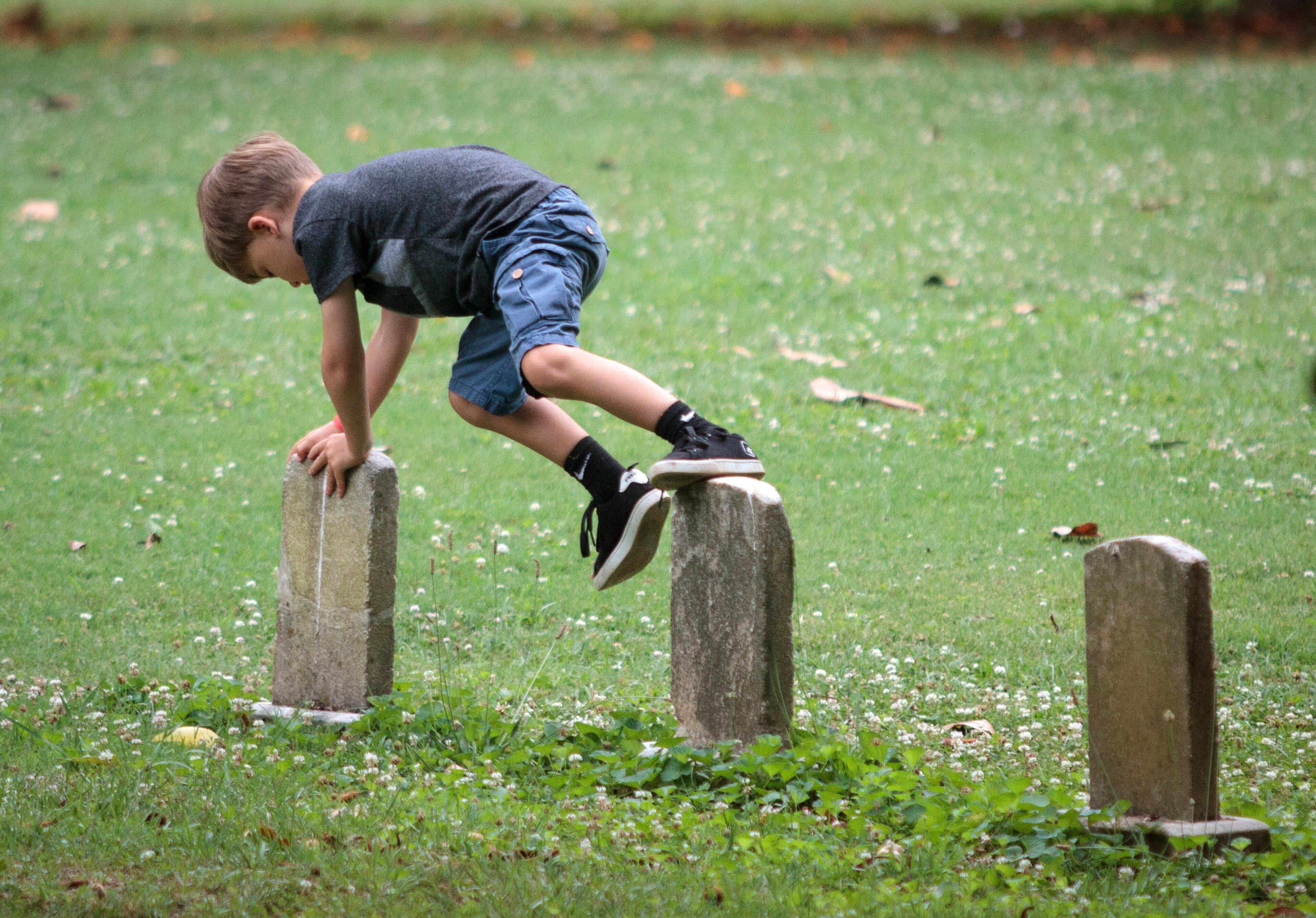 A boy plays on the tombstones, during the Tunes From The Tombs music festival in Oakland Cemetery Saturday, June 18, 2016, in Atlanta, Ga. STEVE SCHAEFER / SPECIAL TO THE AJC