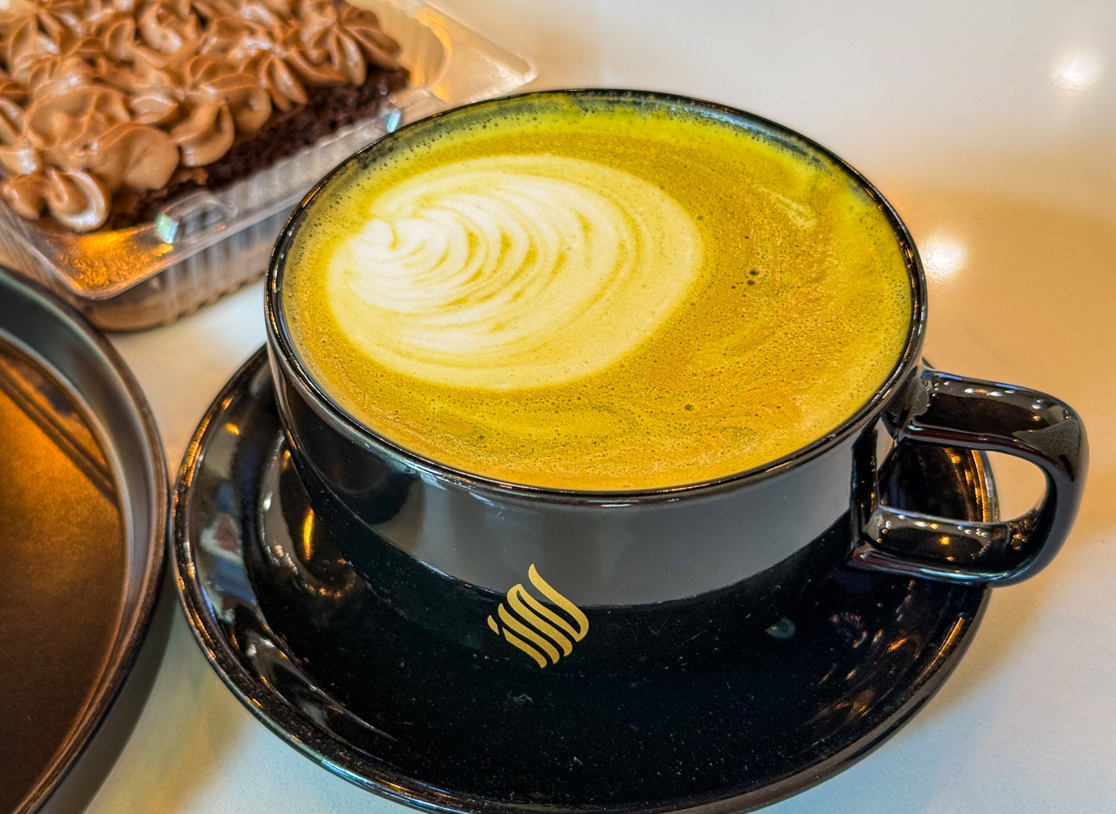 A pistachio latte from Haraz Coffee Roasters in Midtown. (Henri Hollis / AJC)