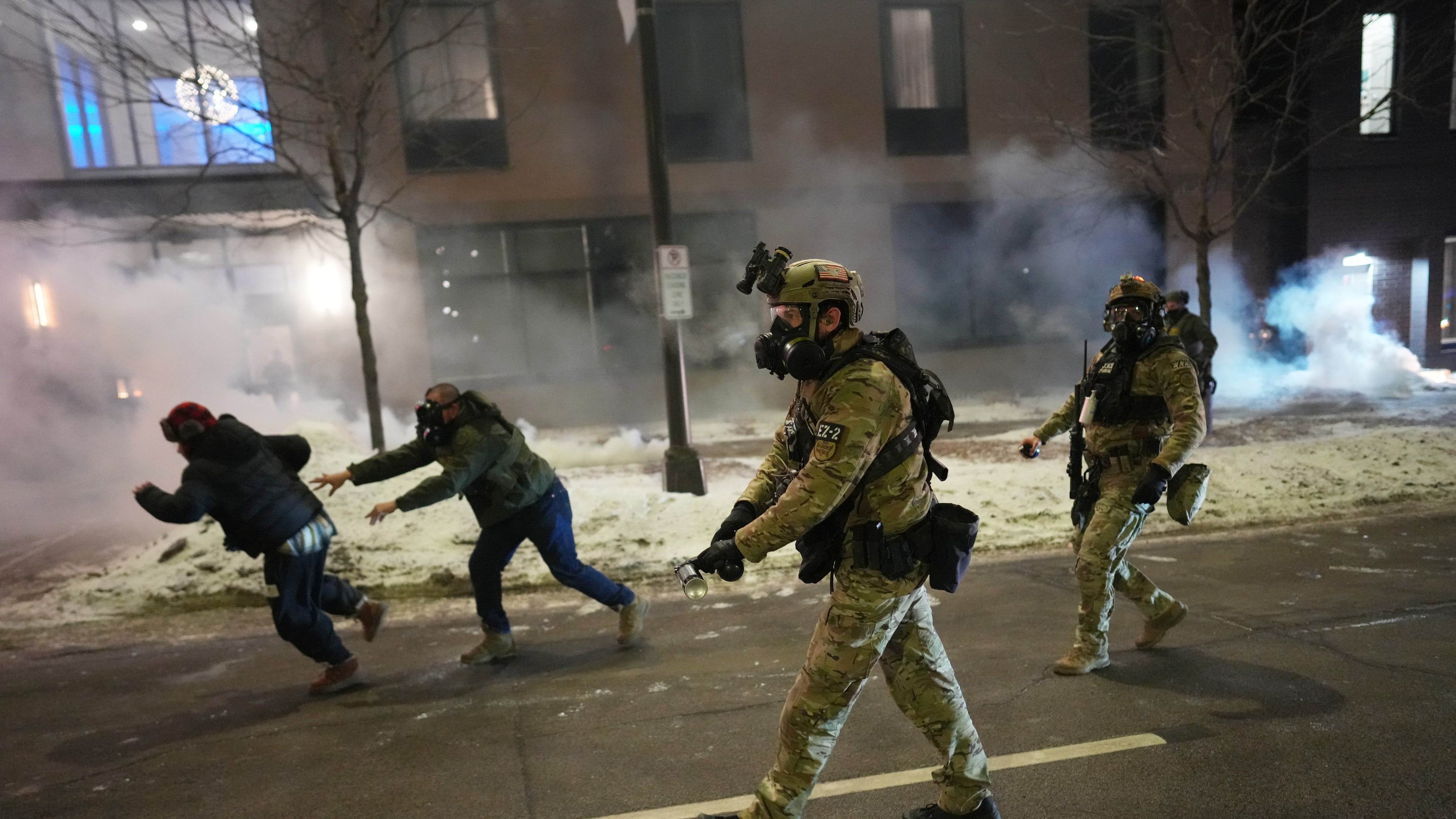 Federal agents try to clear demonstrators near a hotel, using tear gas during a noise demonstration protest in response to federal immigration enforcement operations in the city Sunday, Jan. 25, 2026, in Minneapolis. (AP Photo/Adam Gray)