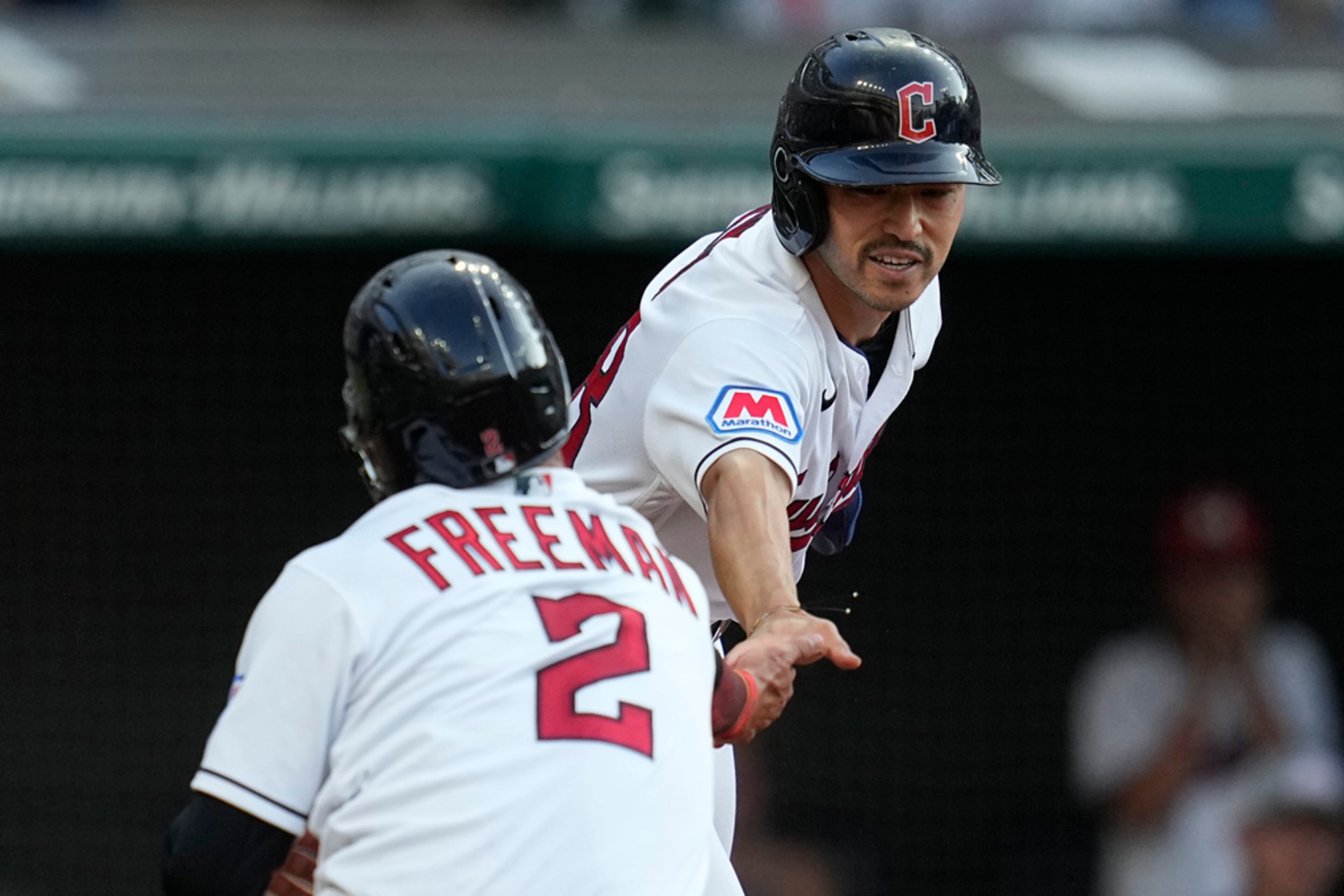 Cleveland Guardians' Steven Kwan, right, celebrates with Tyler Freeman (2) after both scored on a hit by Amed Rosario against the Atlanta Braves during the third inning of a baseball game Tuesday, July 4, 2023, in Cleveland. (AP Photo/Sue Ogrocki)