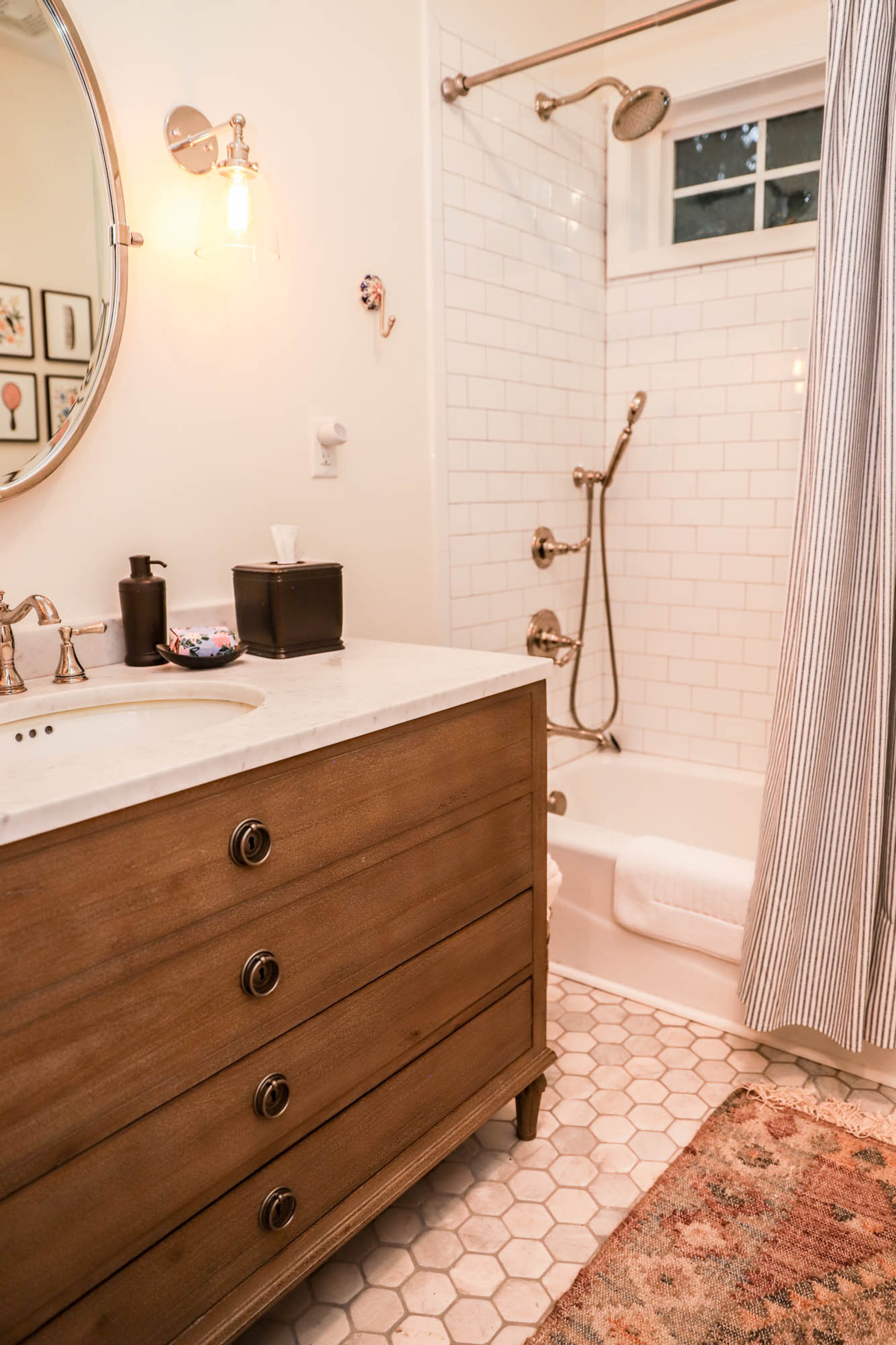 In the renovated guest bathroom, the Wells created a classic look with honeycomb tile on the floor and subway tile in the shower. The vanity is from RH.