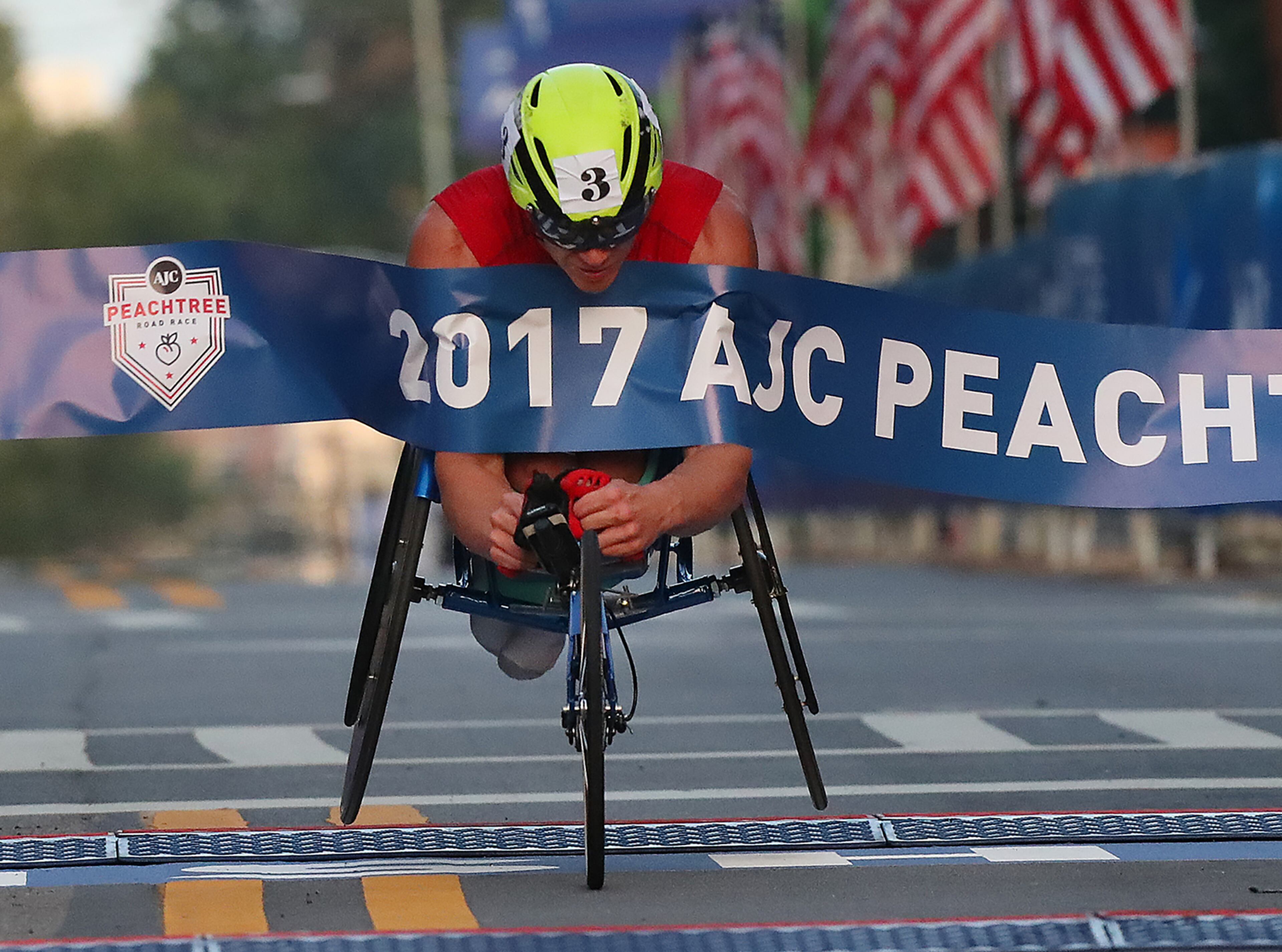 Daniel Romanchuk hits the finish line to win the men's wheelchair race in 2017. Curtis Compton/ccompton@ajc.com
