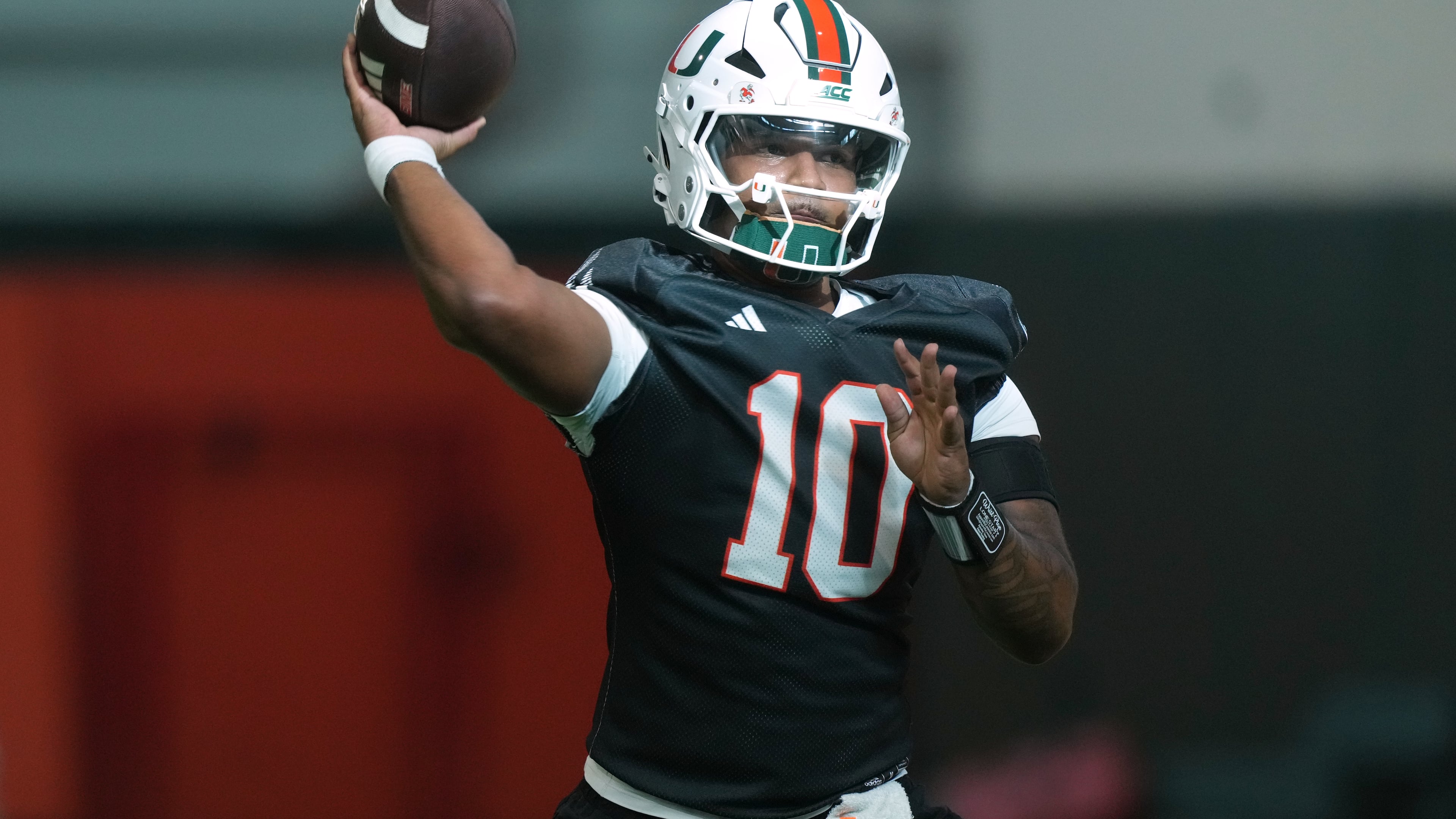 Miami quarterback Darian Mensah (10) throws a pass during a practice session at their training facility, Tuesday, Aug. 4, 2026, in Coral Gables, Fla. (AP Photo/Marta Lavandier)