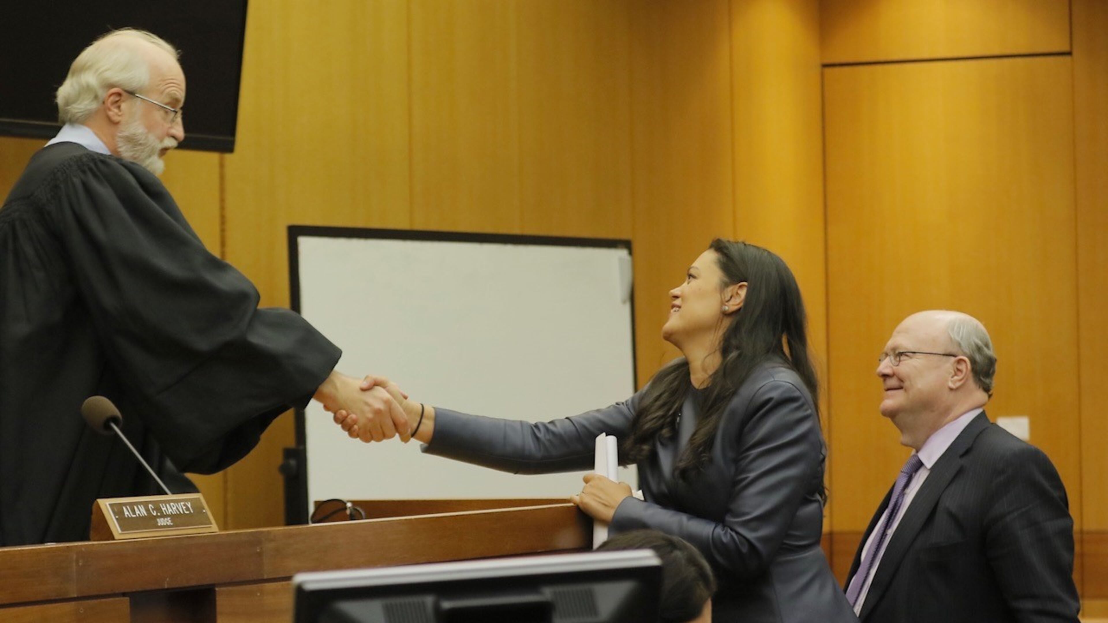 APS superintendent Meria Carstarphen shakes the hand of DeKalb County Judge Alan C. Harvey on Friday after he gave Fulton County permission to send tax bills.
