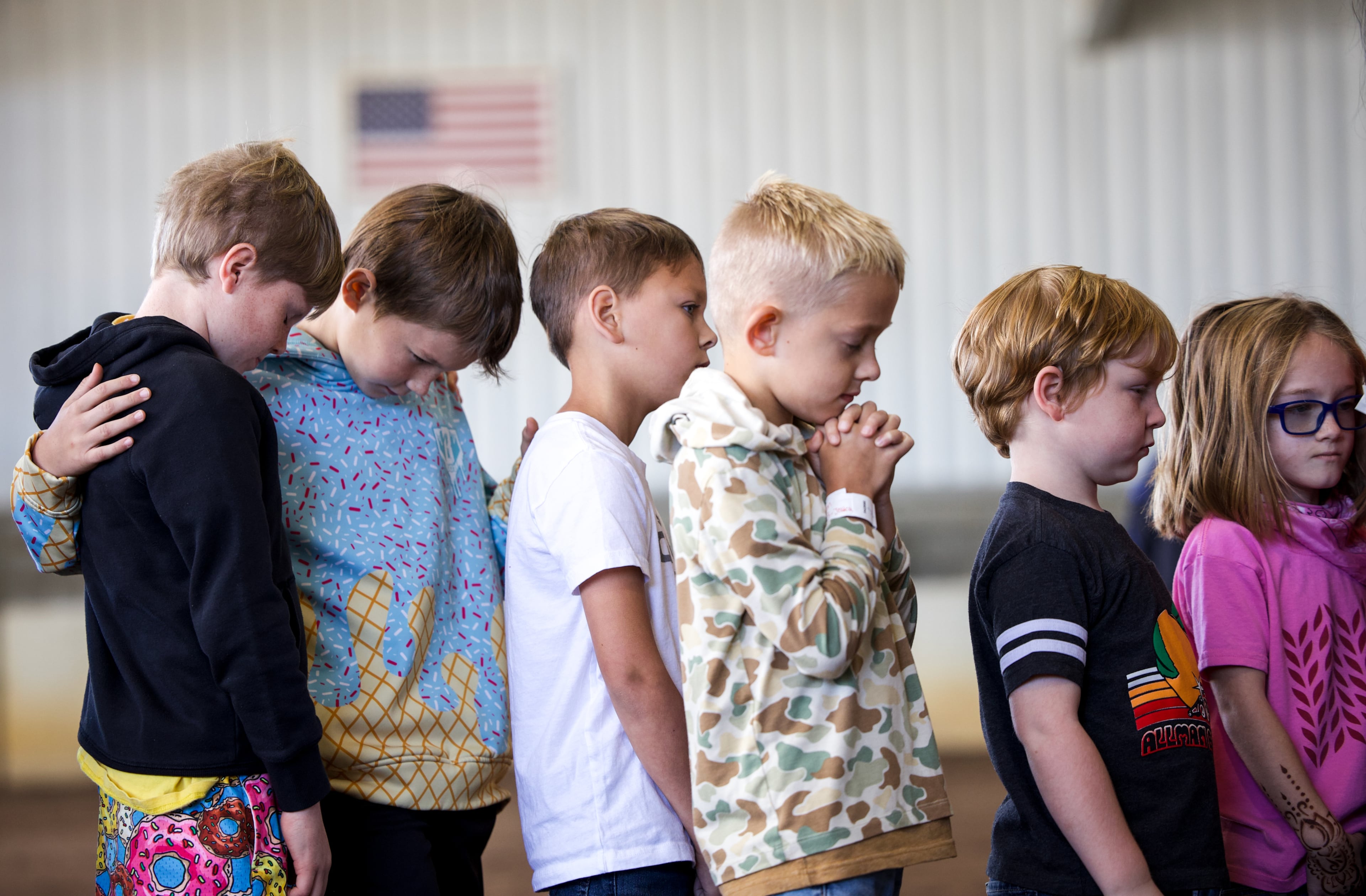 Participants of the mutton bustin' competition pray before the event at the Georgia National Fair in Perry, Georgia, on Oct. 17, 2026. Participants were children ages 4 to 8 who weighed less than 65 pounds. (Emily Laycock/UGA Photojournalism Workshop)