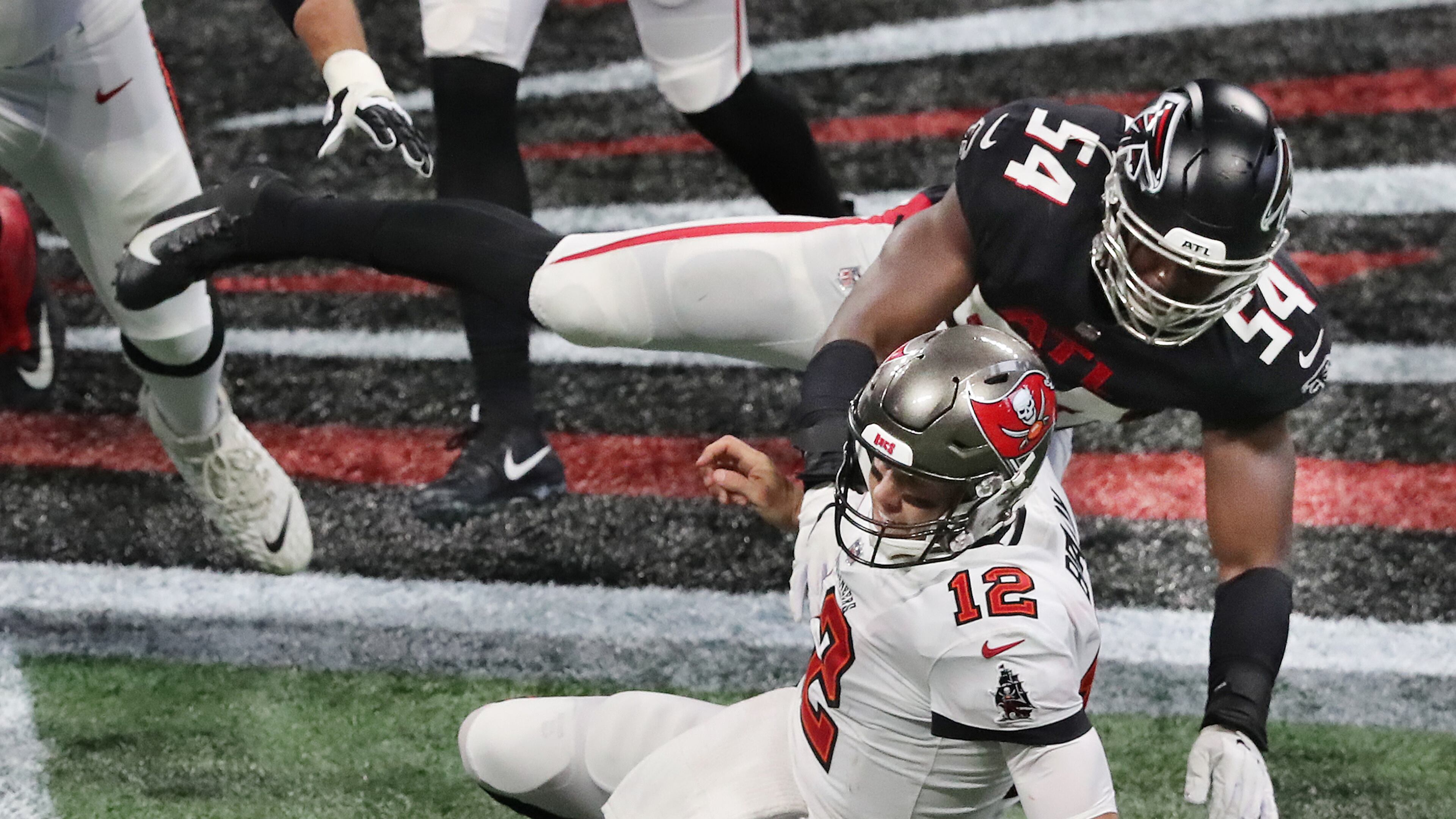 Falcons linebacker Foye Oluokun knocks Buccaneers quarterback Tom Brady to the turf. Oluokun has decided to leave the Falcons, and Brady plans to play another season (at least) in the NFL. (Curtis Compton / Curtis.Compton@ajc.com)