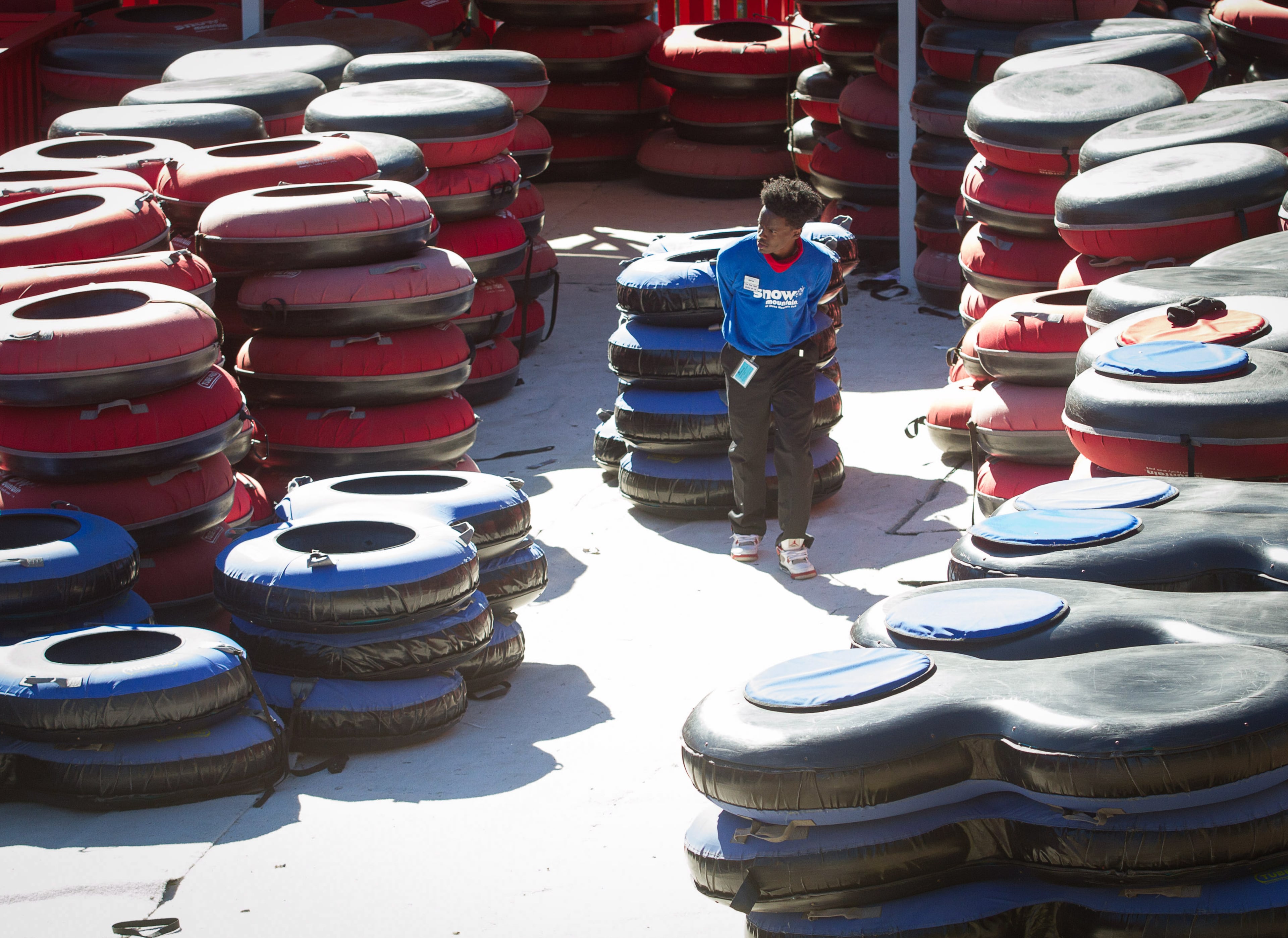 Kyrus Robinson organizes the inner tubes at Snow Mountain in Stone Mountain Park Sunday, November 26, 2017. Stone Mountain manufactures 360 tons of snow every day to accommodate the 400-foot tubing hill. STEVE SCHAEFER / SPECIAL TO THE AJC