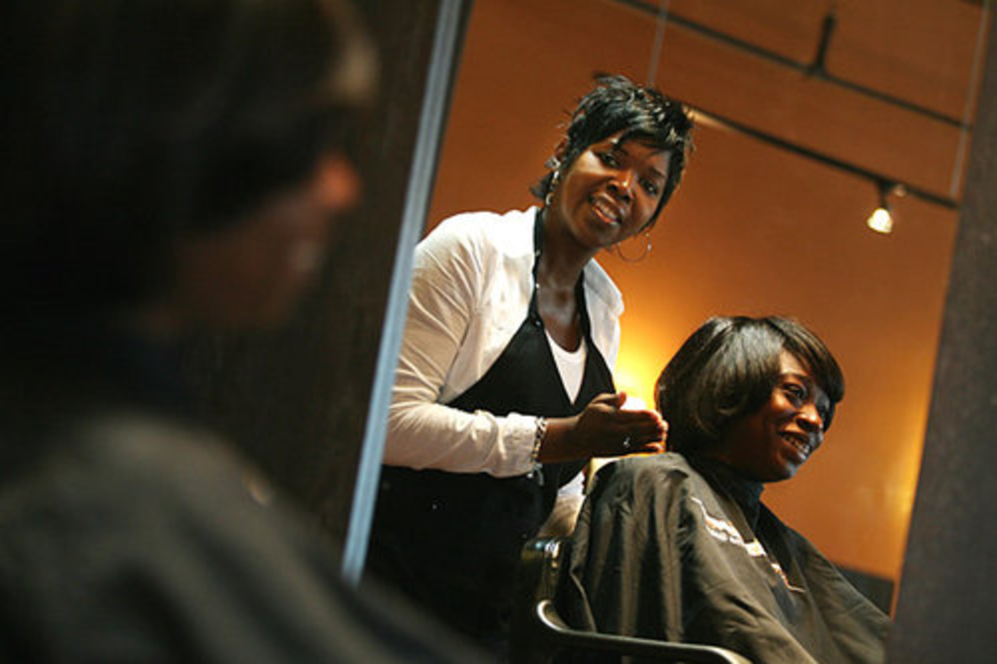 Najah Aziz (left) puts the finishing touches on the new haircut for Tushynya Gardiner.