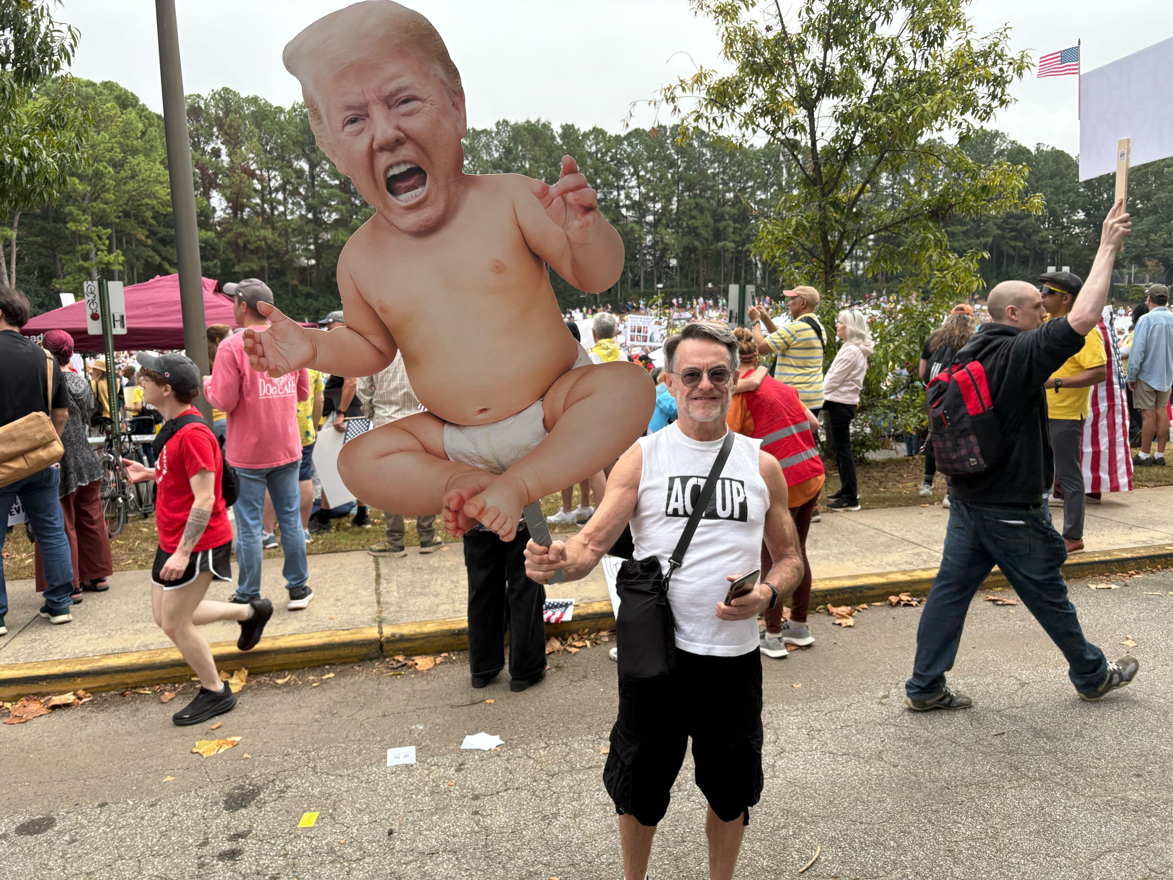 At the No Kings rally at the Atlanta Civic Center on Saturday, Oct. 18, 2025, retired English professor Mike Hall holds a massive sign showing President Donald Trump depicted as a baby. “This pretty much sums it up without any words,” the Scottdale man said of his sign. (Shaddi Abusaid/AJC)